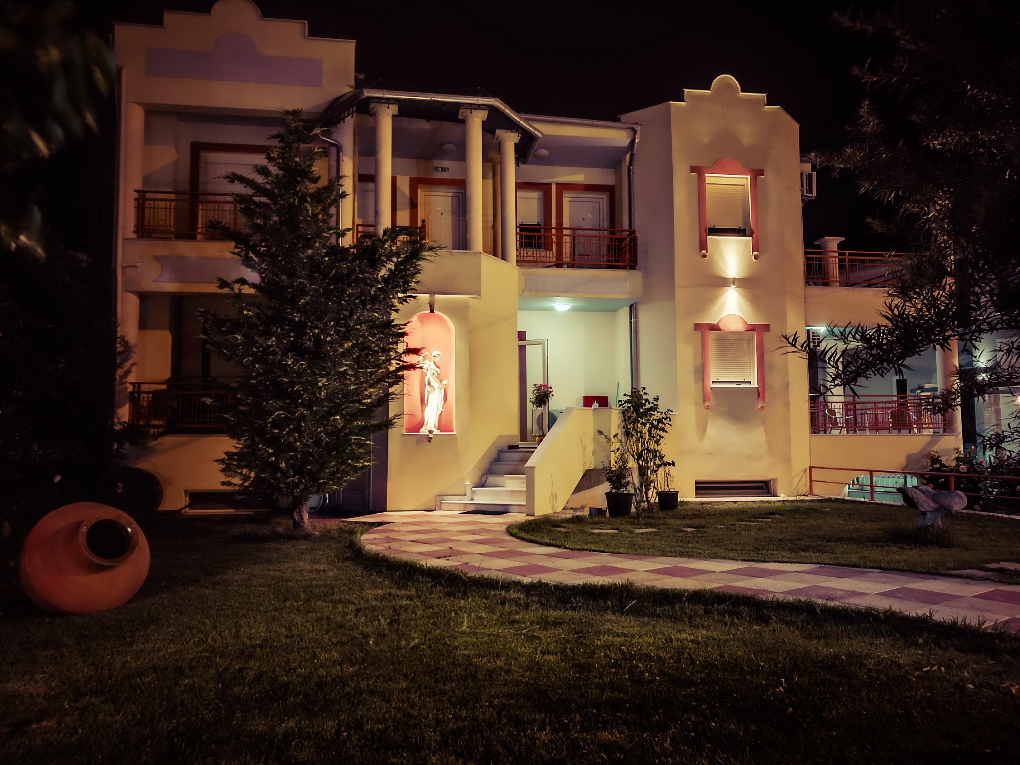 Building at night with a statue and a large pot HD Wallpaper