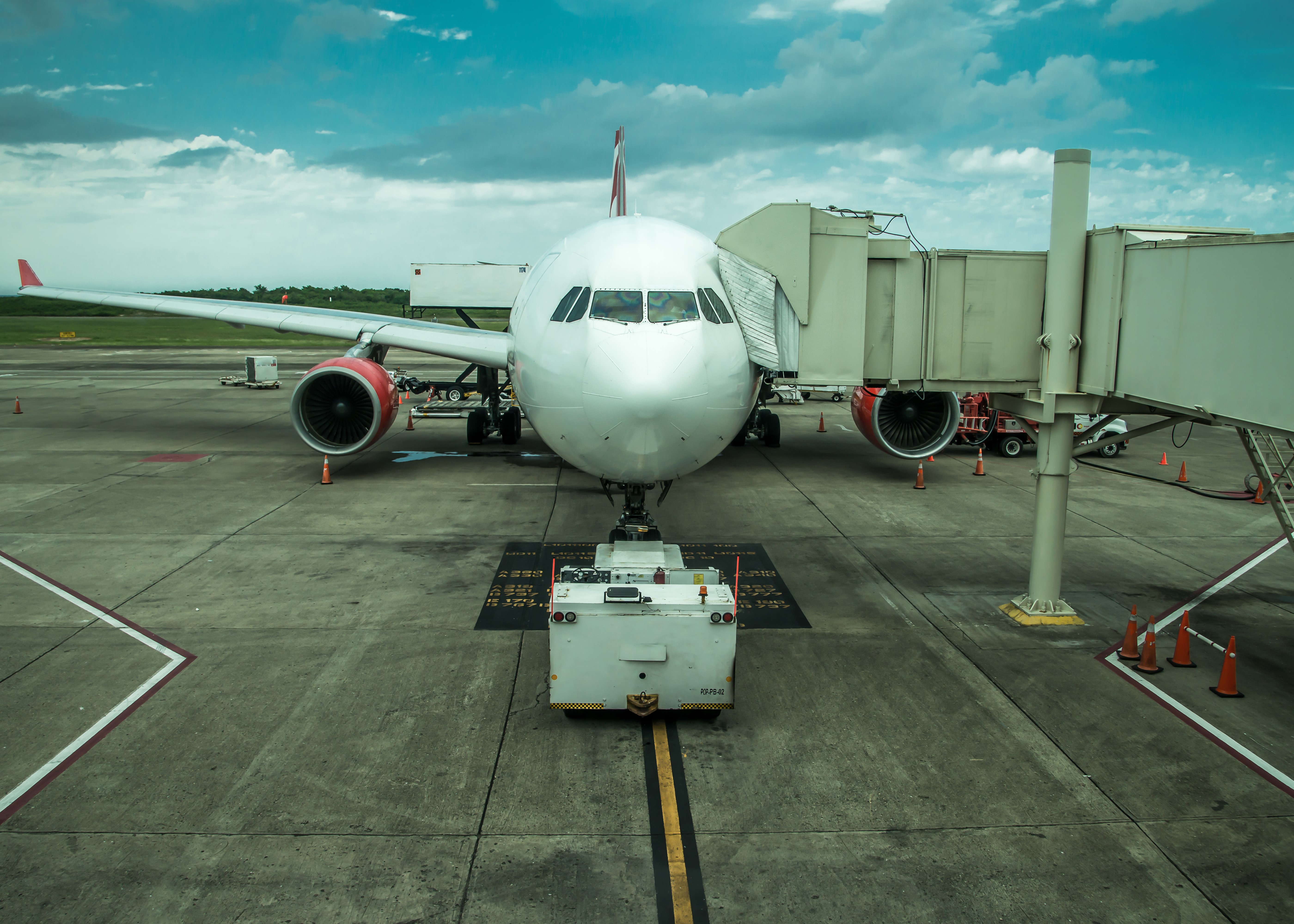 Airplane at airport gate with jet bridge HD Wallpaper