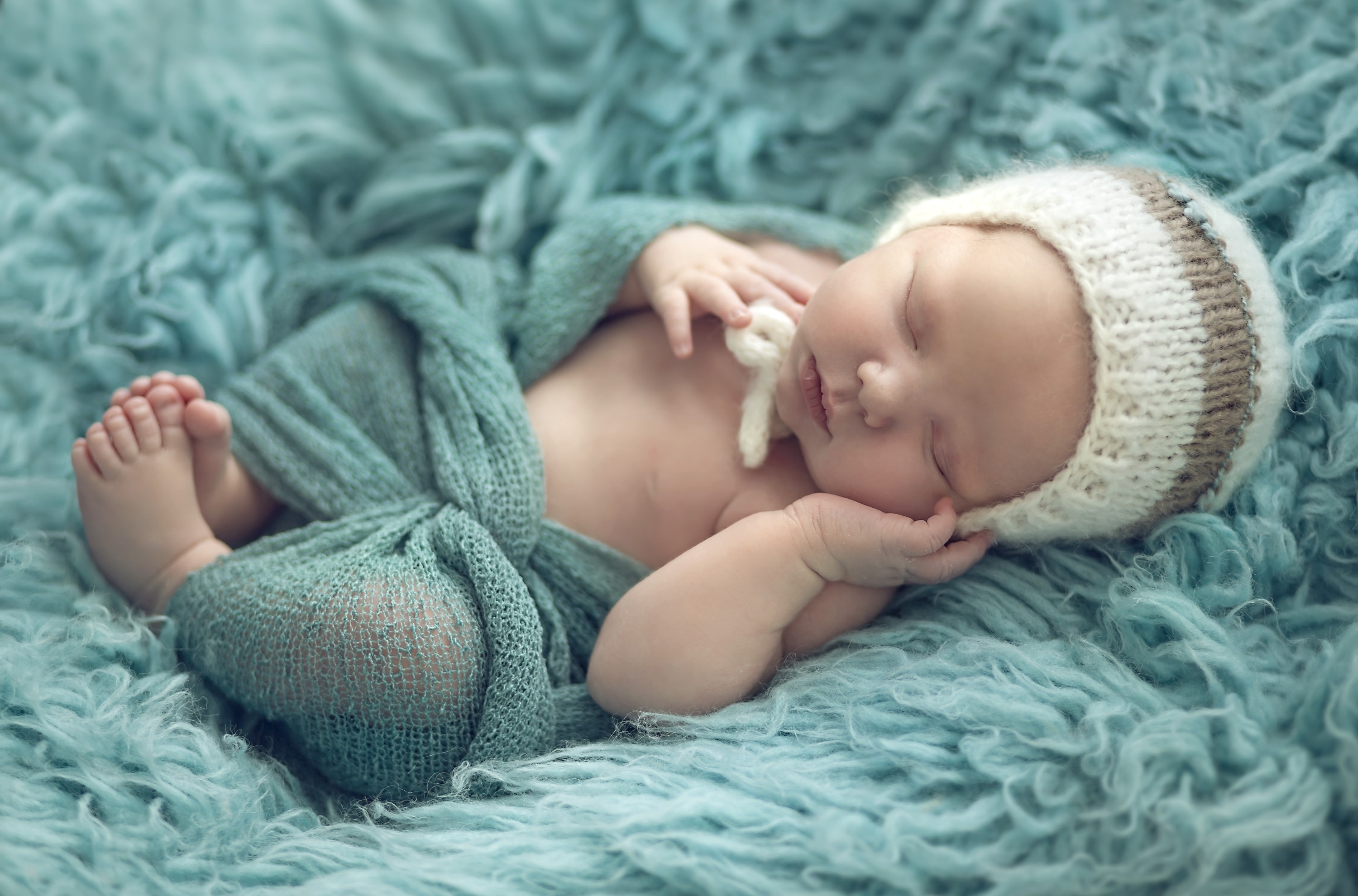 Newborn baby sleeping in a knitted hat HD Wallpaper