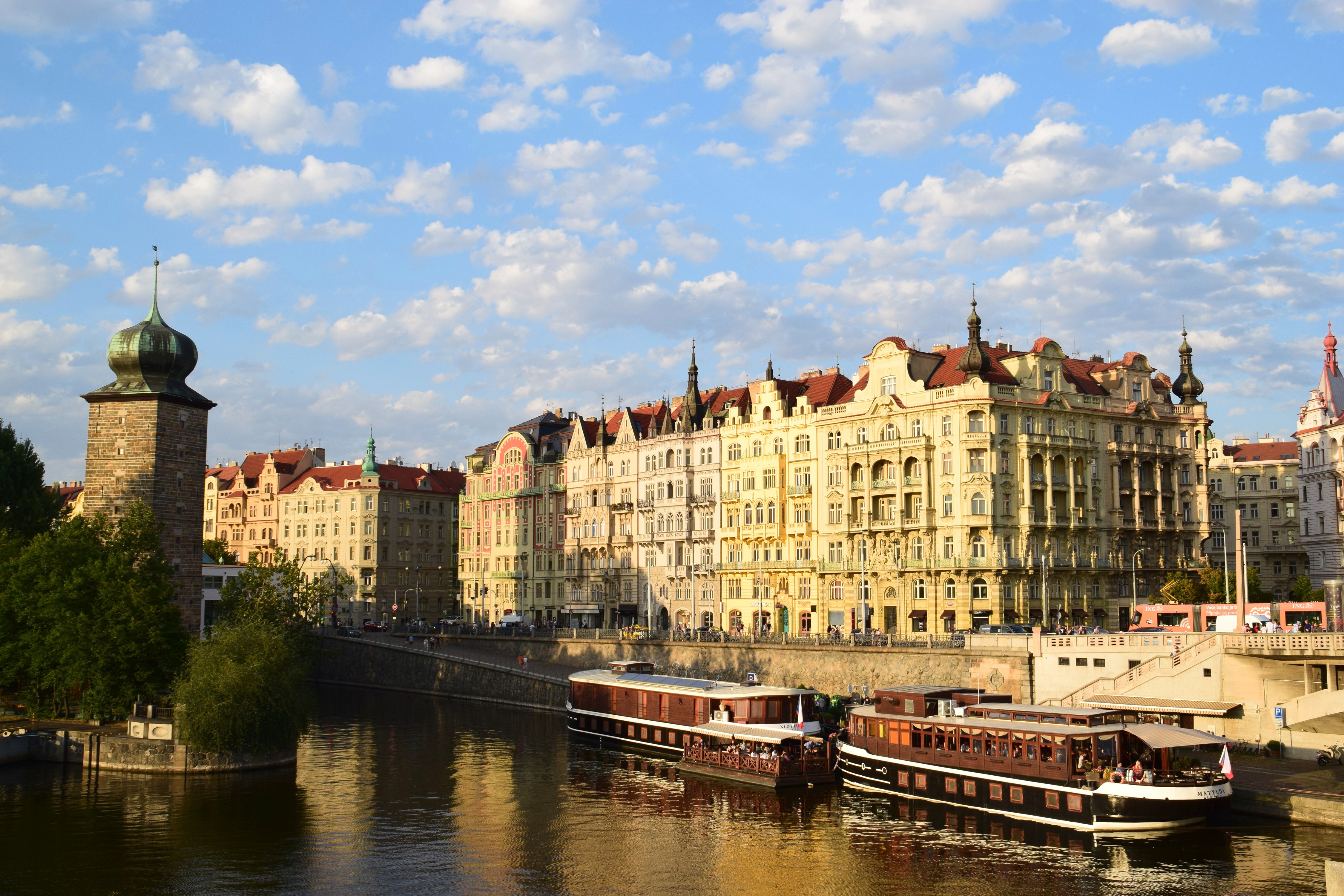 Prague, Czech Republic riverfront with historic buildings and boats HD Wallpaper