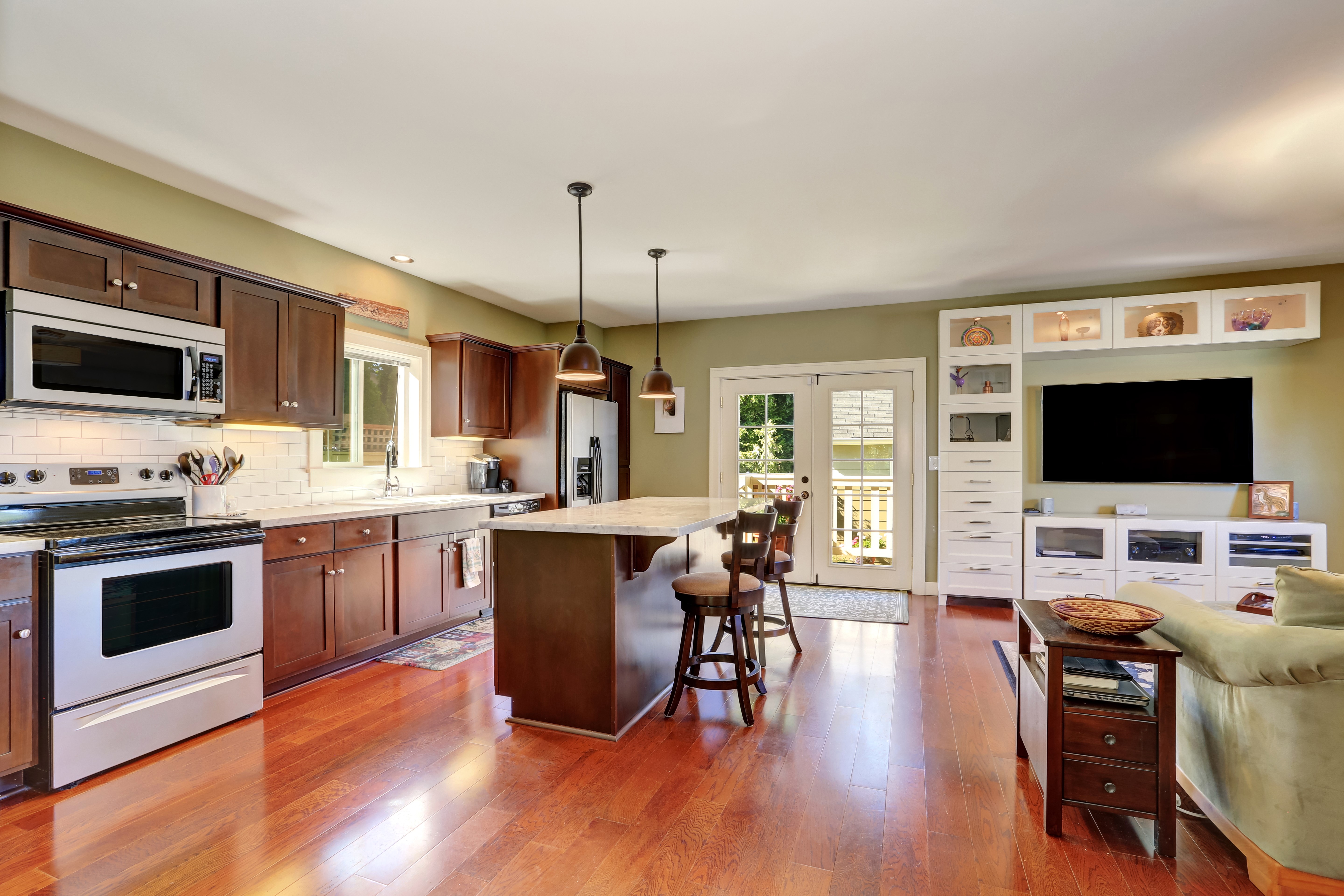 Kitchen with island, dining area, and living room with TV HD Wallpaper