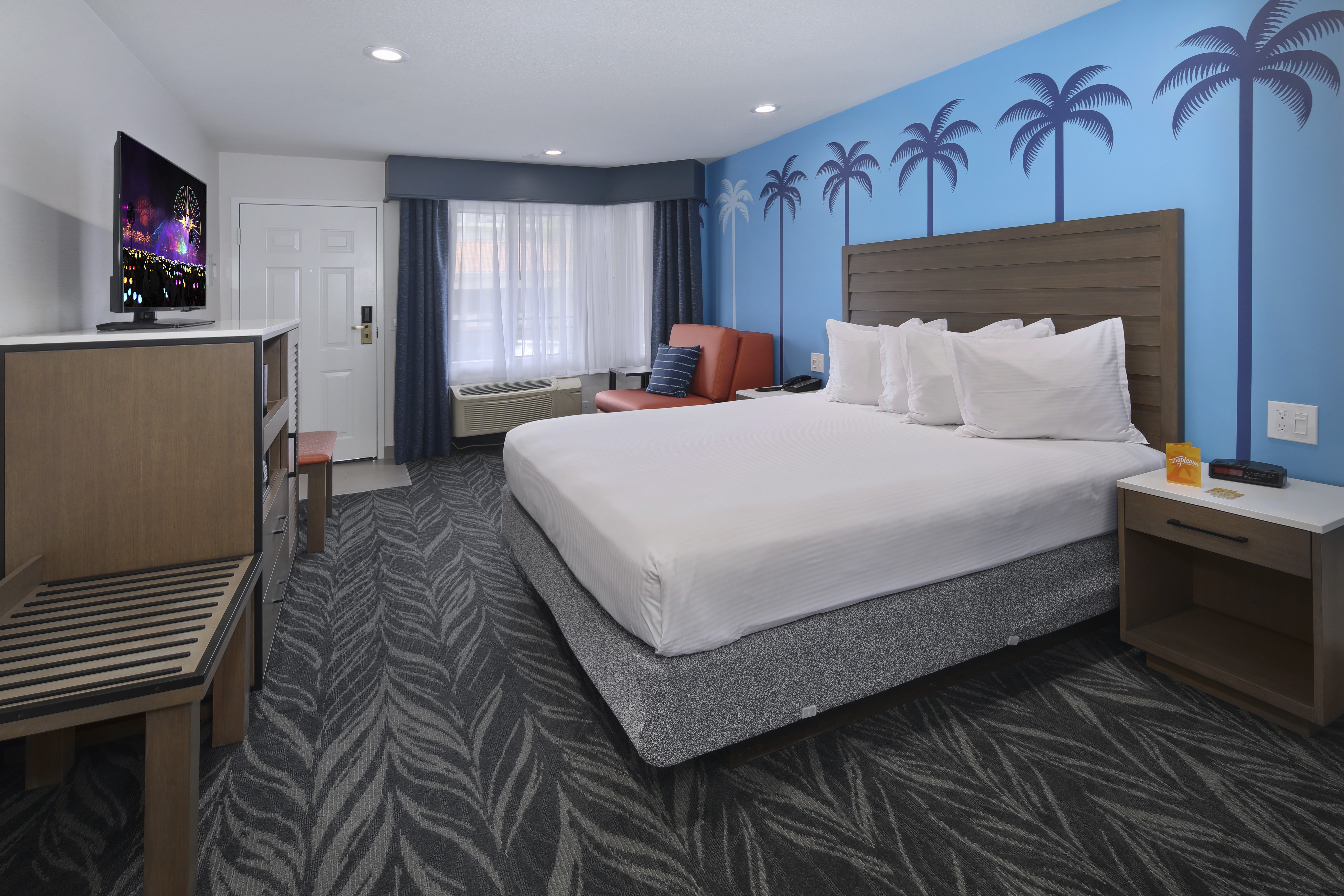 Bedroom with bed, TV, and palm tree mural HD Wallpaper