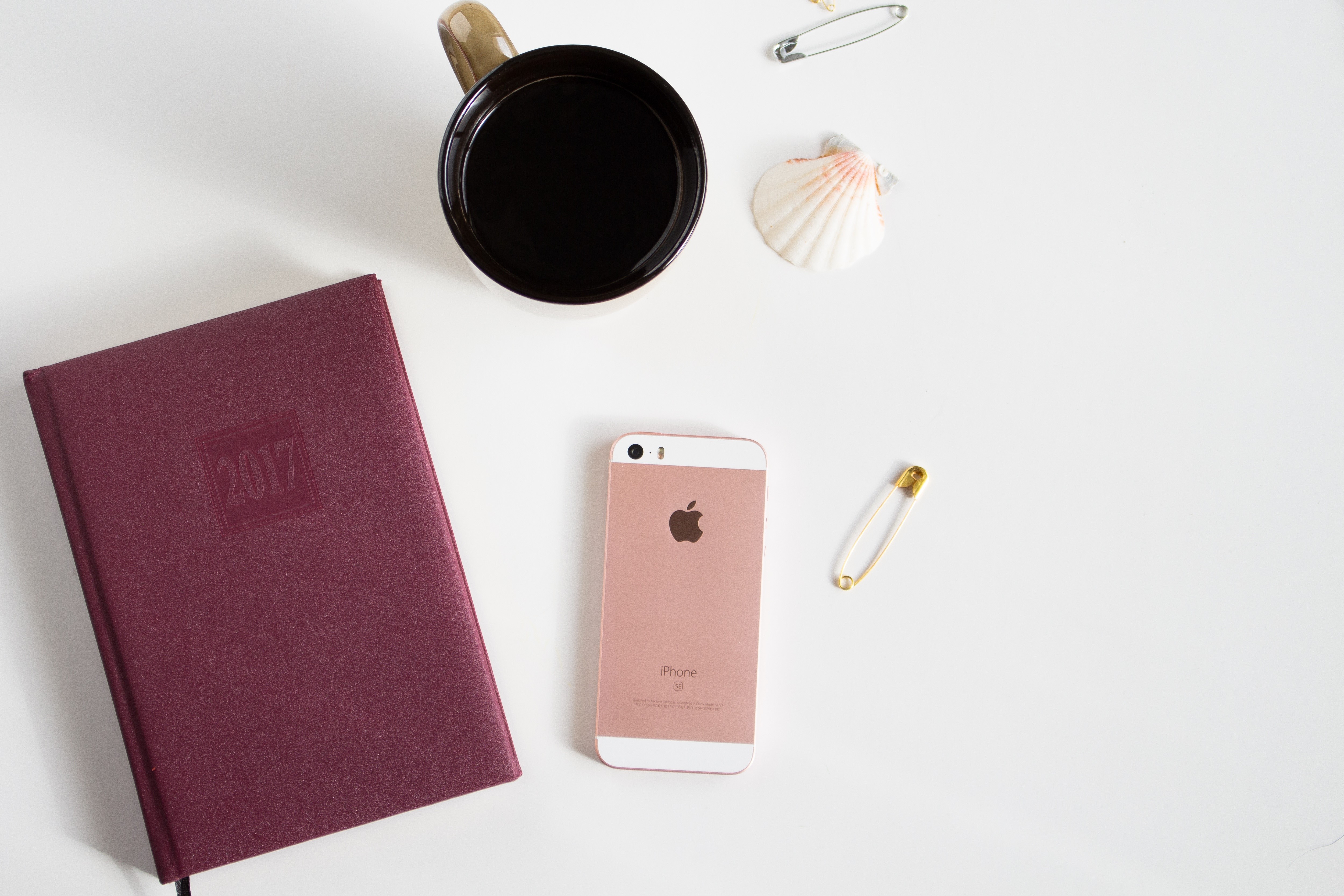 iPhone, Notepad, Cup, and Shell on White Surface HD Wallpaper