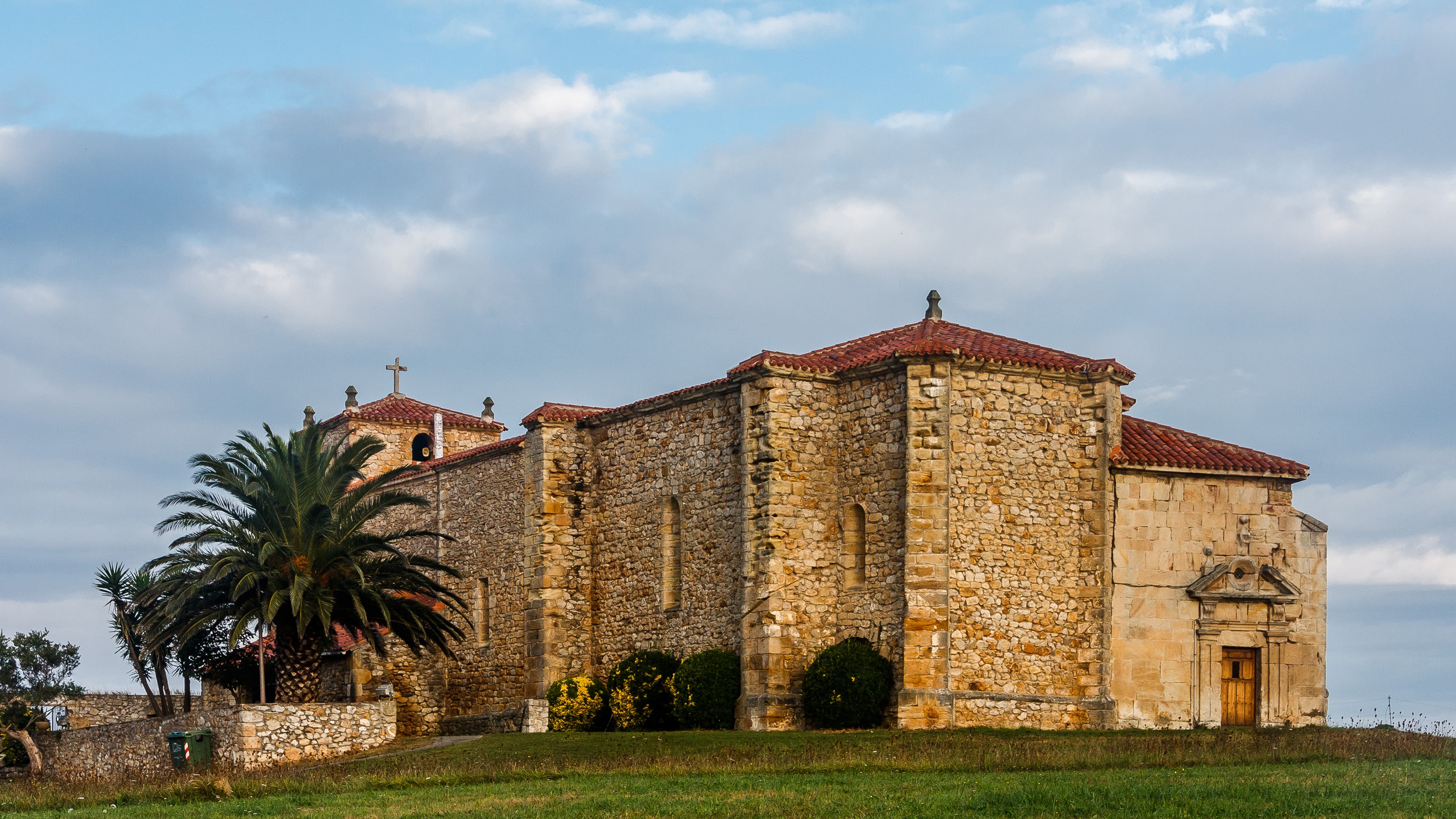 Stone church with palm tree in Cantabria, Spain HD Wallpaper