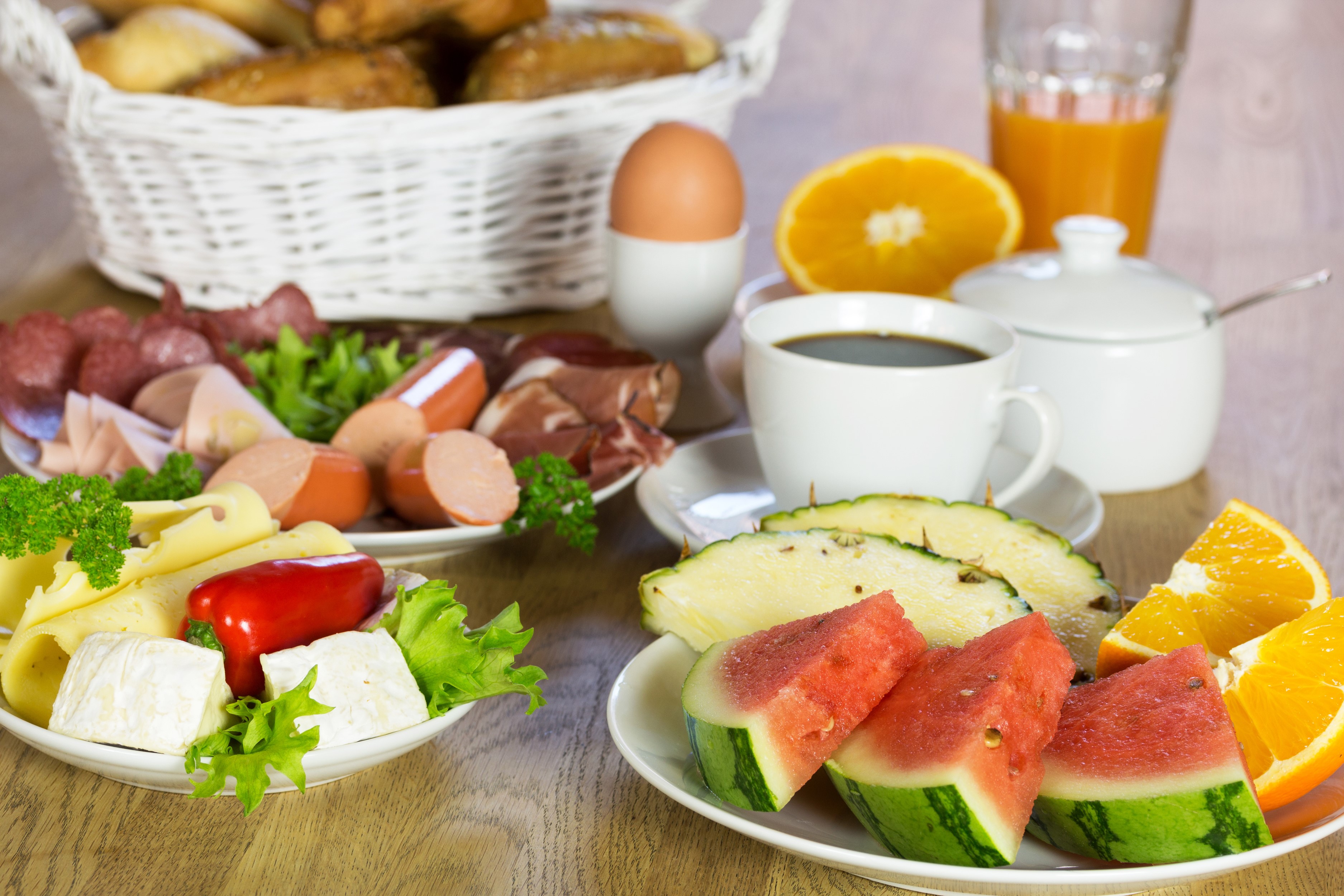 Breakfast spread with fruits, cheese, meats, and coffee HD Wallpaper