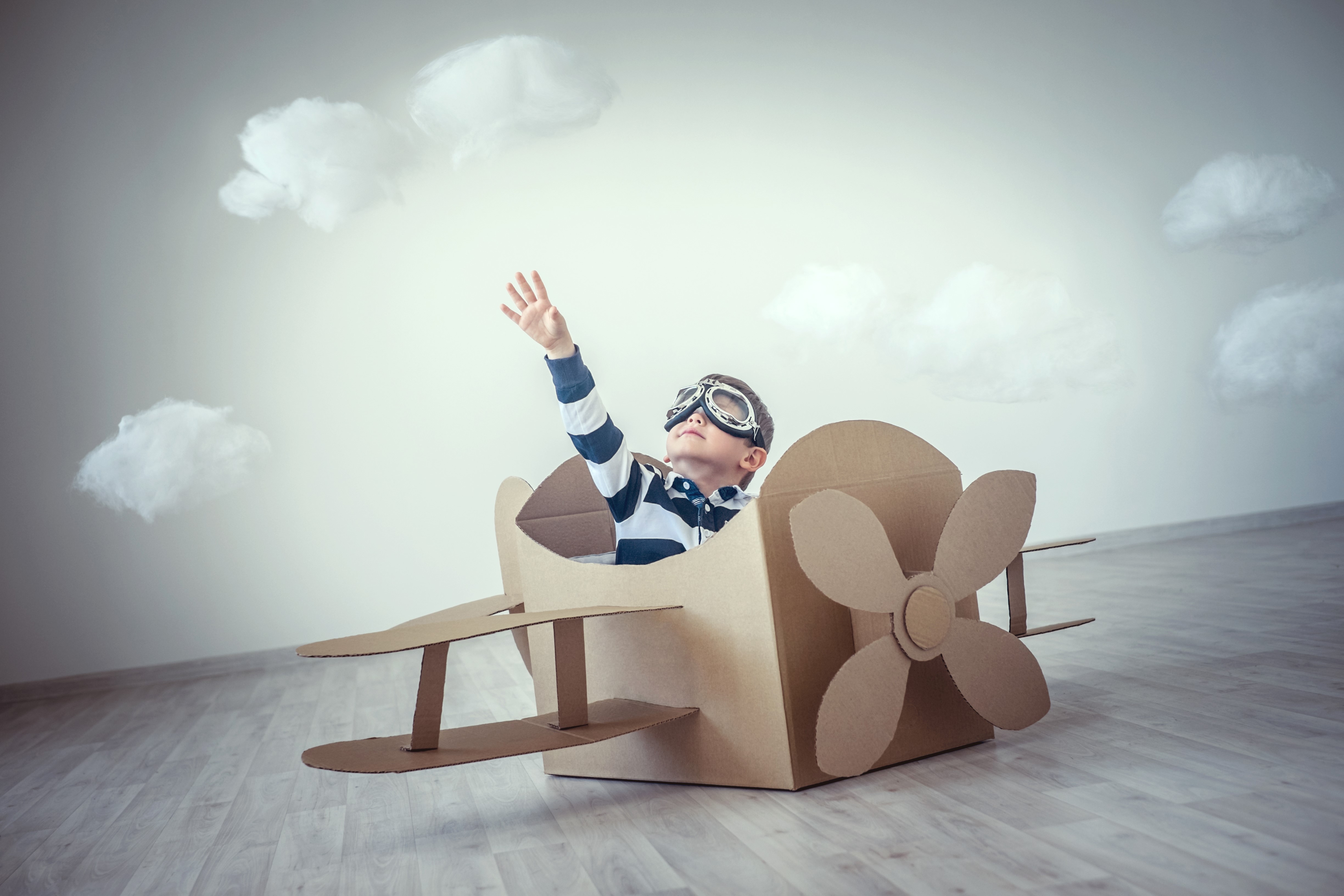 Boy in cardboard airplane with goggles HD Wallpaper