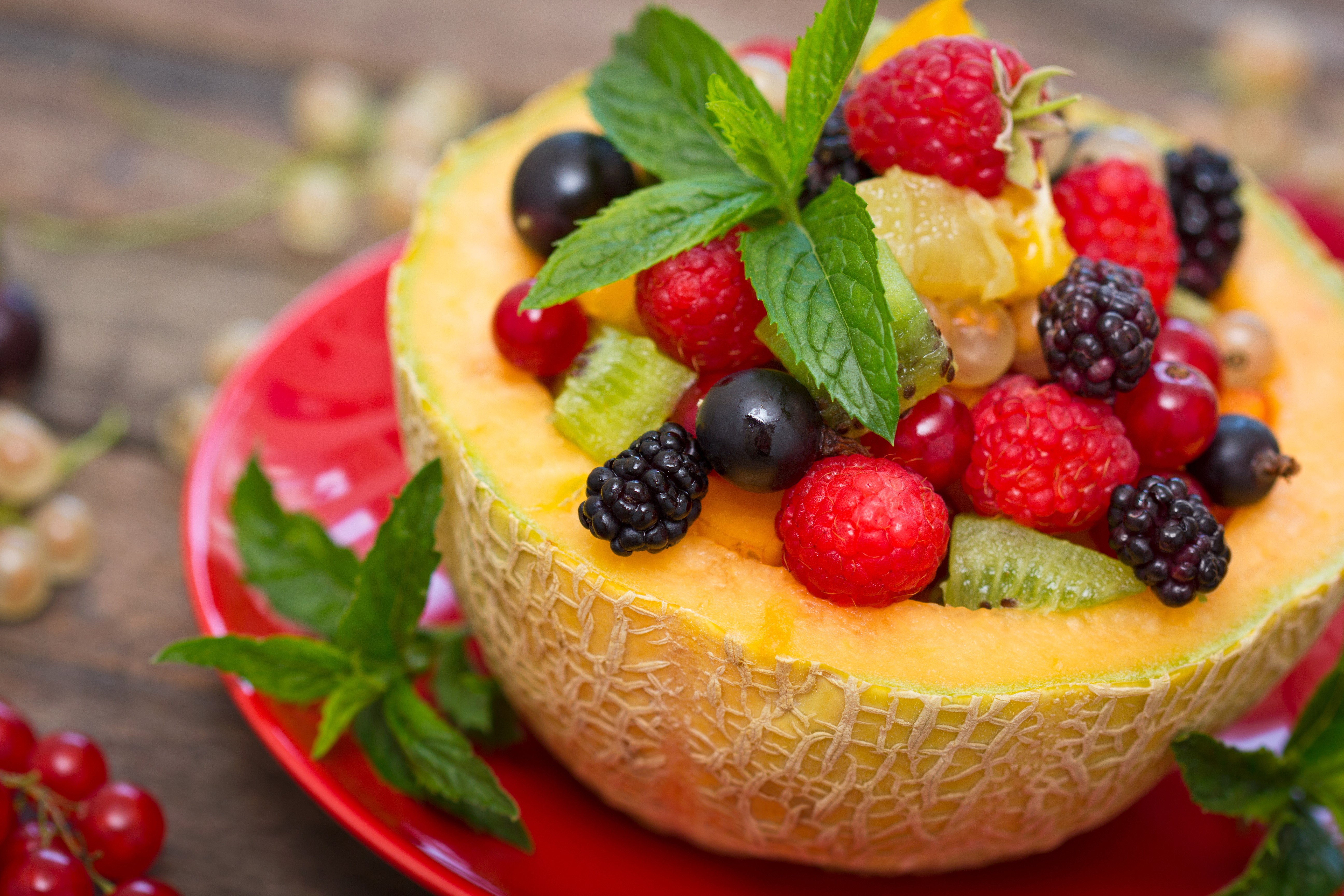 Fruit salad in a cantaloupe bowl with berries and mint HD Wallpaper