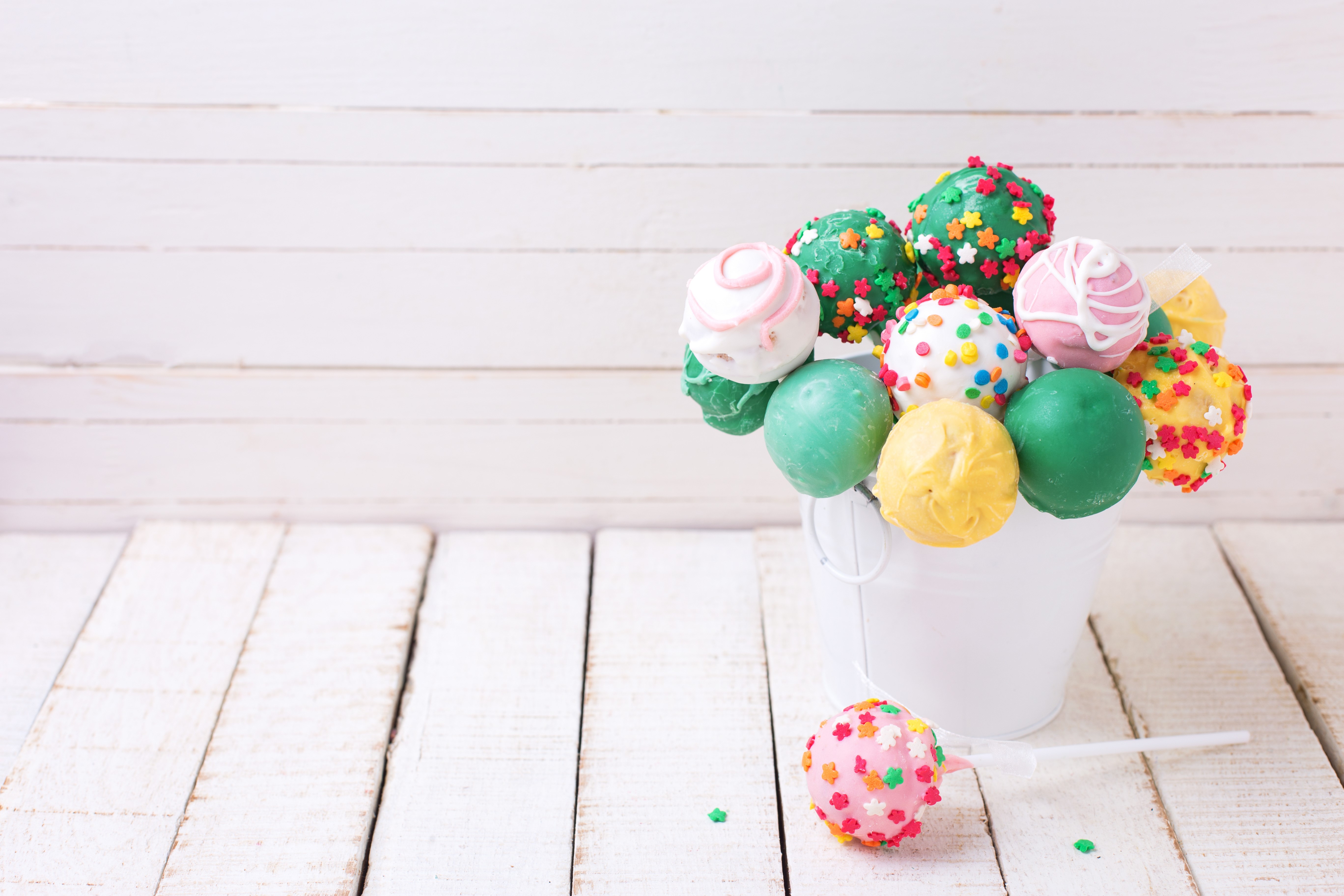 Cake pops in a bucket on a wooden table HD Wallpaper