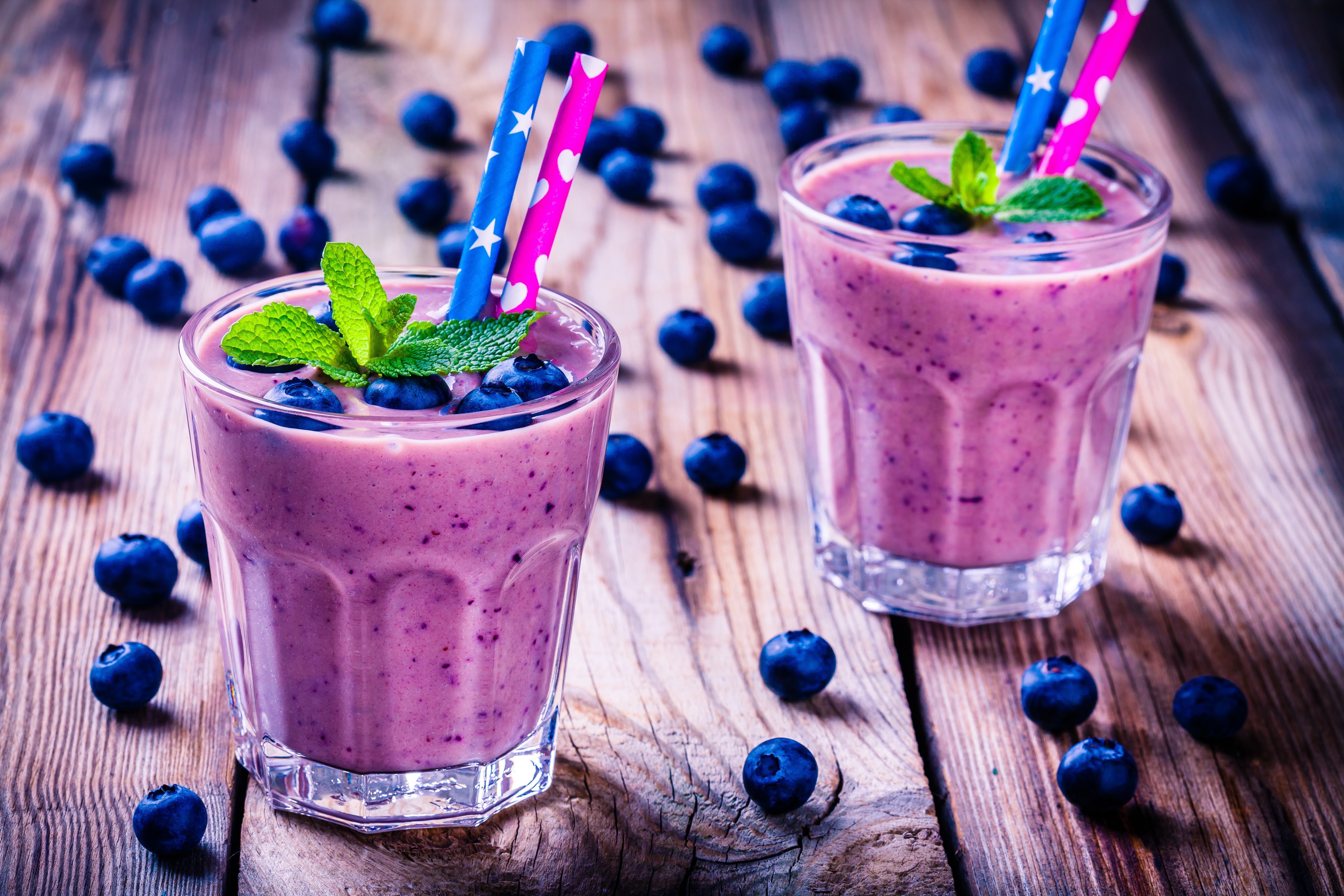 Two blueberry smoothies with mint and blueberries on wood planks HD Wallpaper