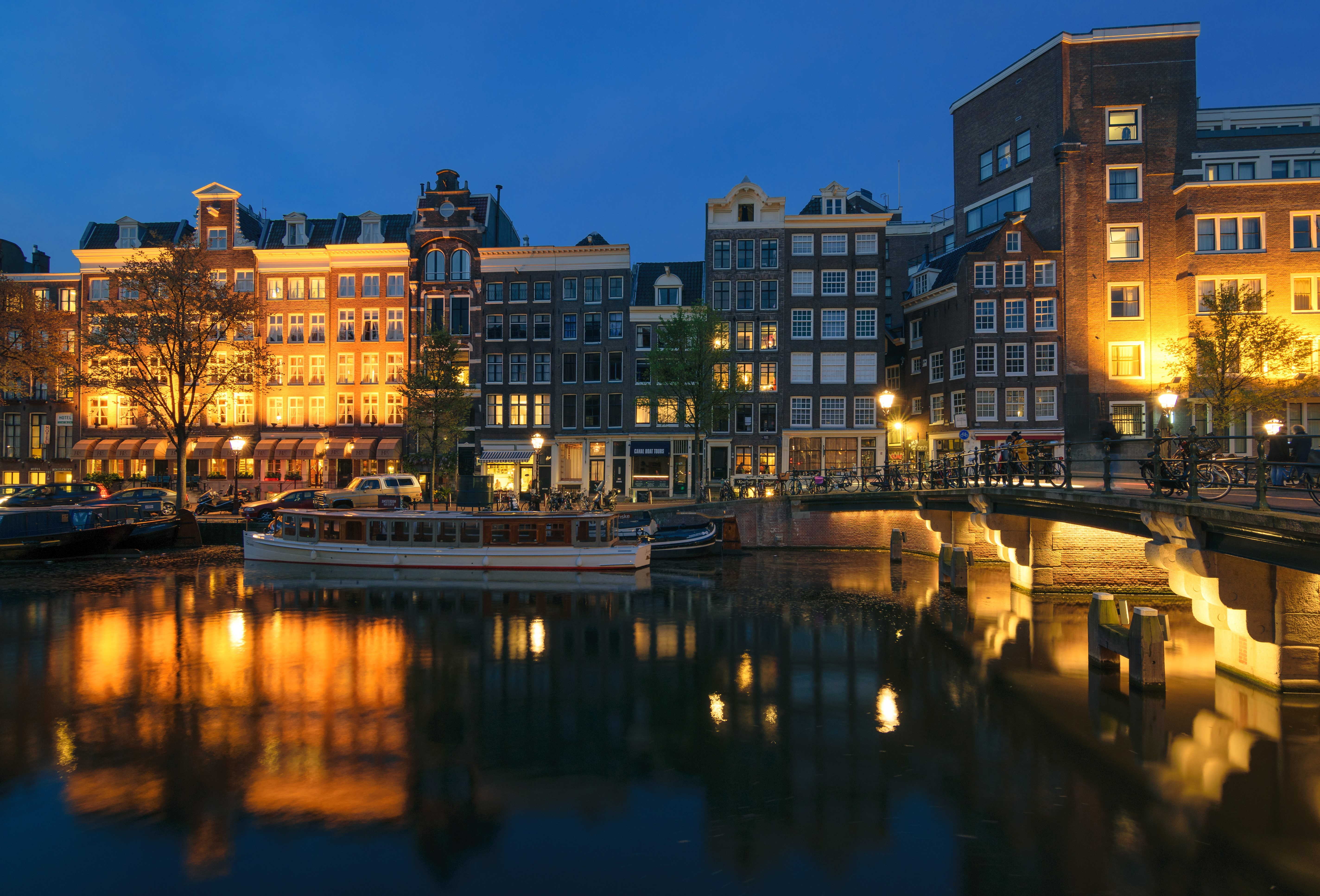 Amsterdam Canal at Dusk with Riverboat and Bridge HD Wallpaper