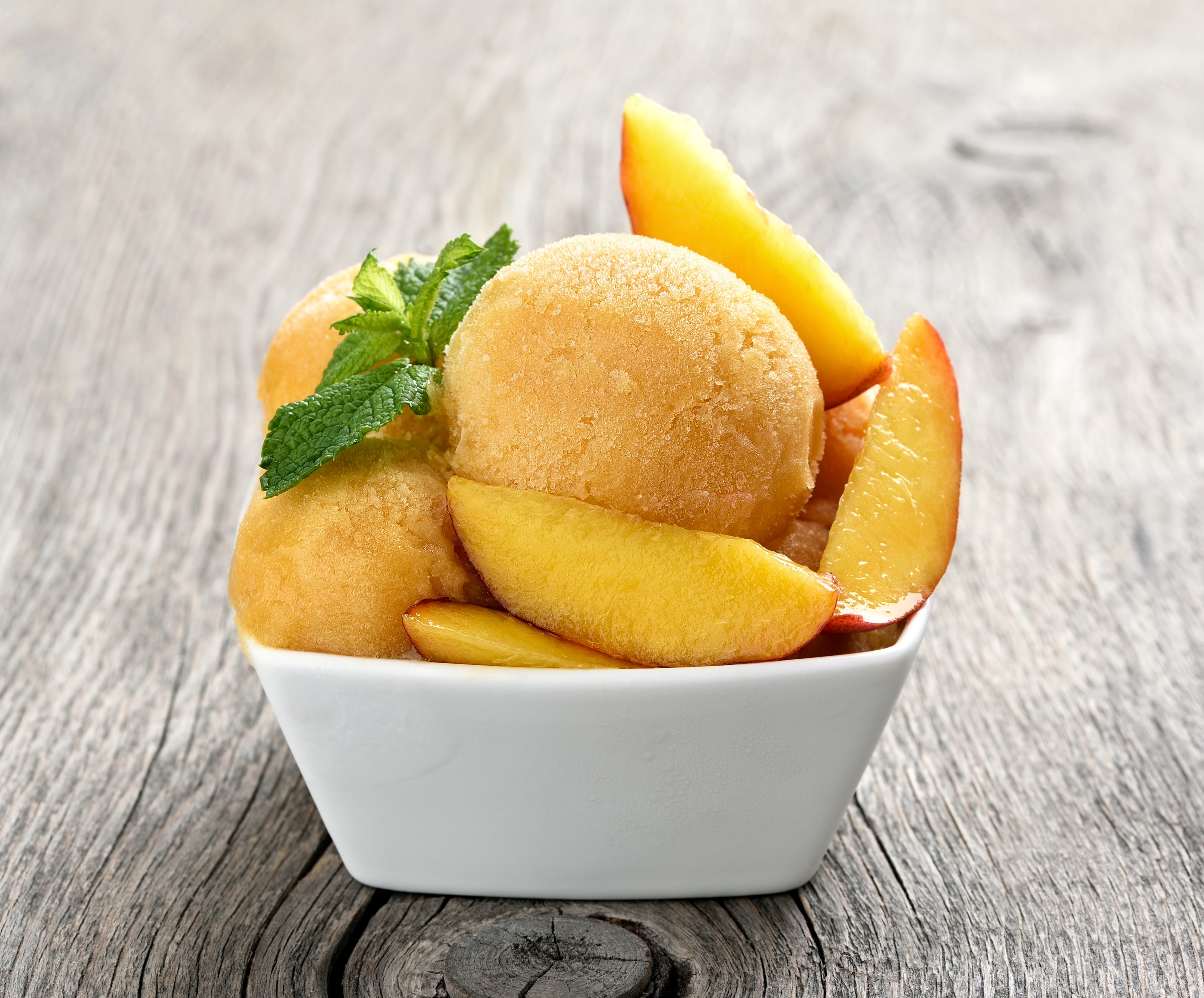 Peach sorbet with mint and peach slices in a bowl HD Wallpaper