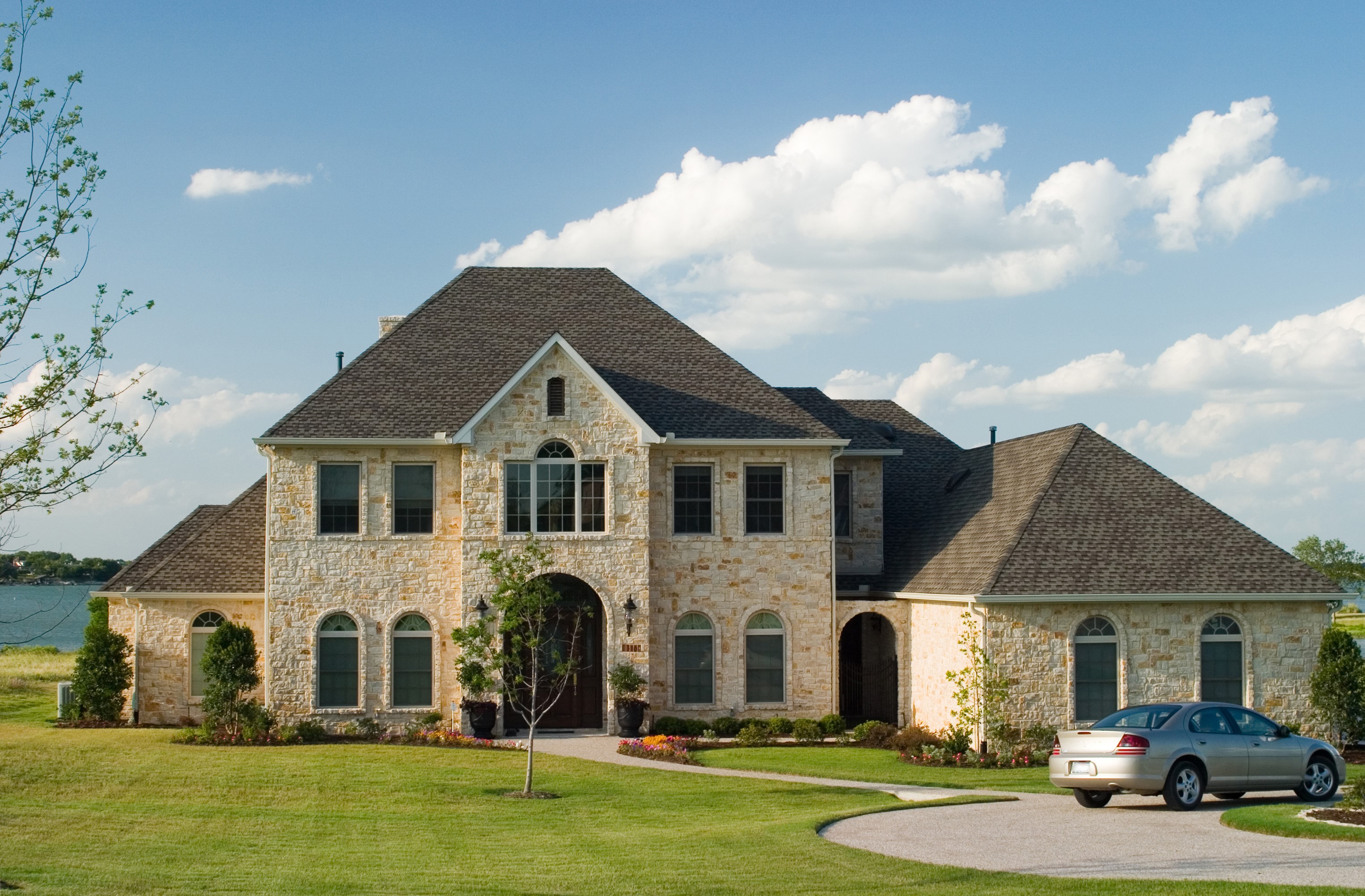 Large stone house with a car on the lawn HD Wallpaper