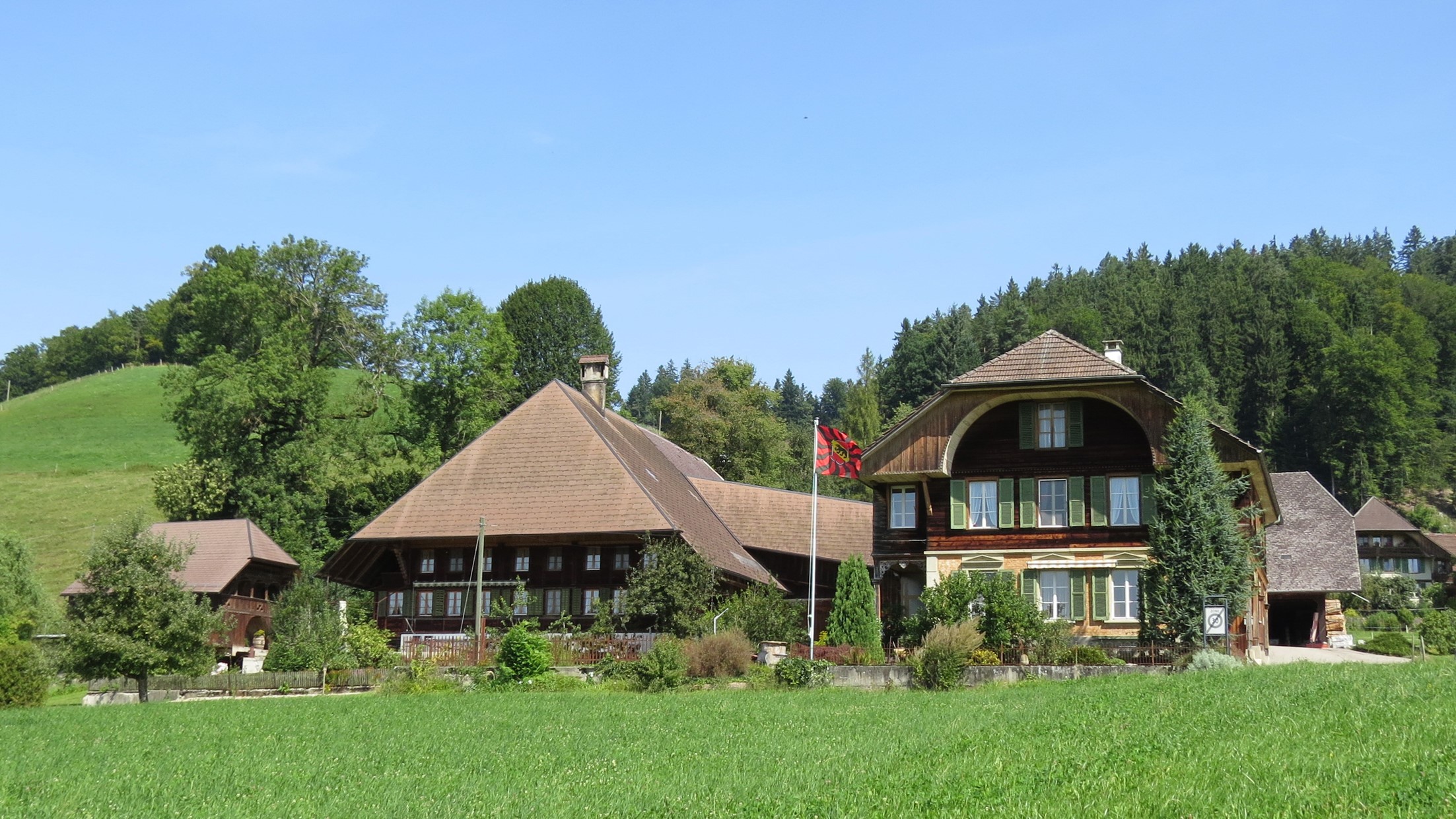 Wooden houses in Lutzelfluh, Switzerland with a grassy field HD Wallpaper