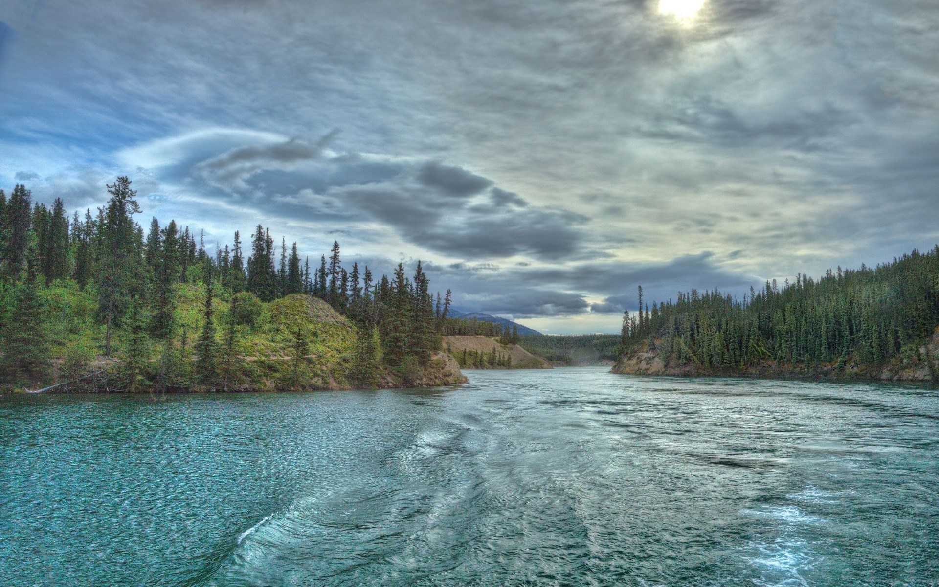 River flowing through a forest under a cloudy sky HD Wallpaper