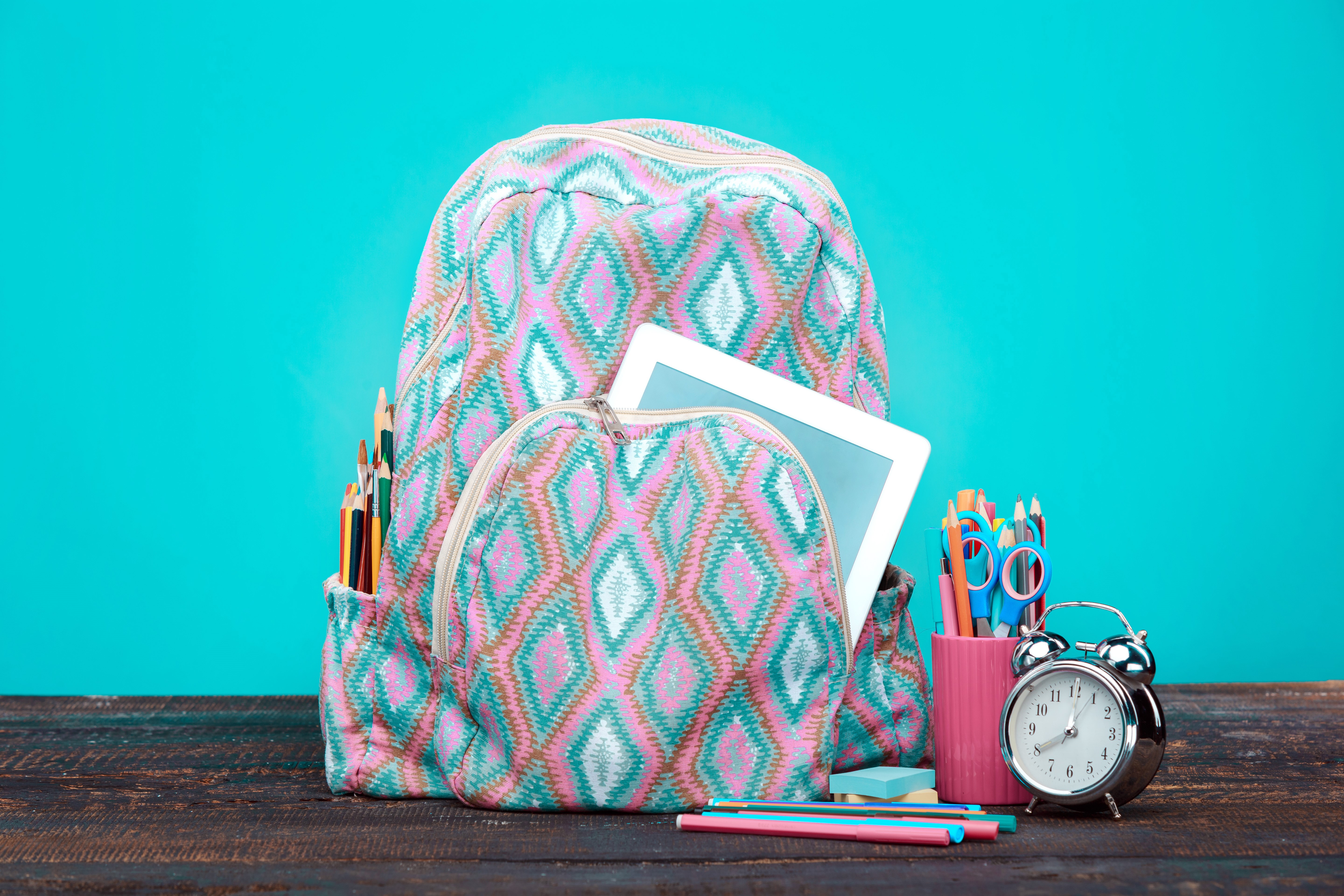 Backpack with school supplies and alarm clock HD Wallpaper