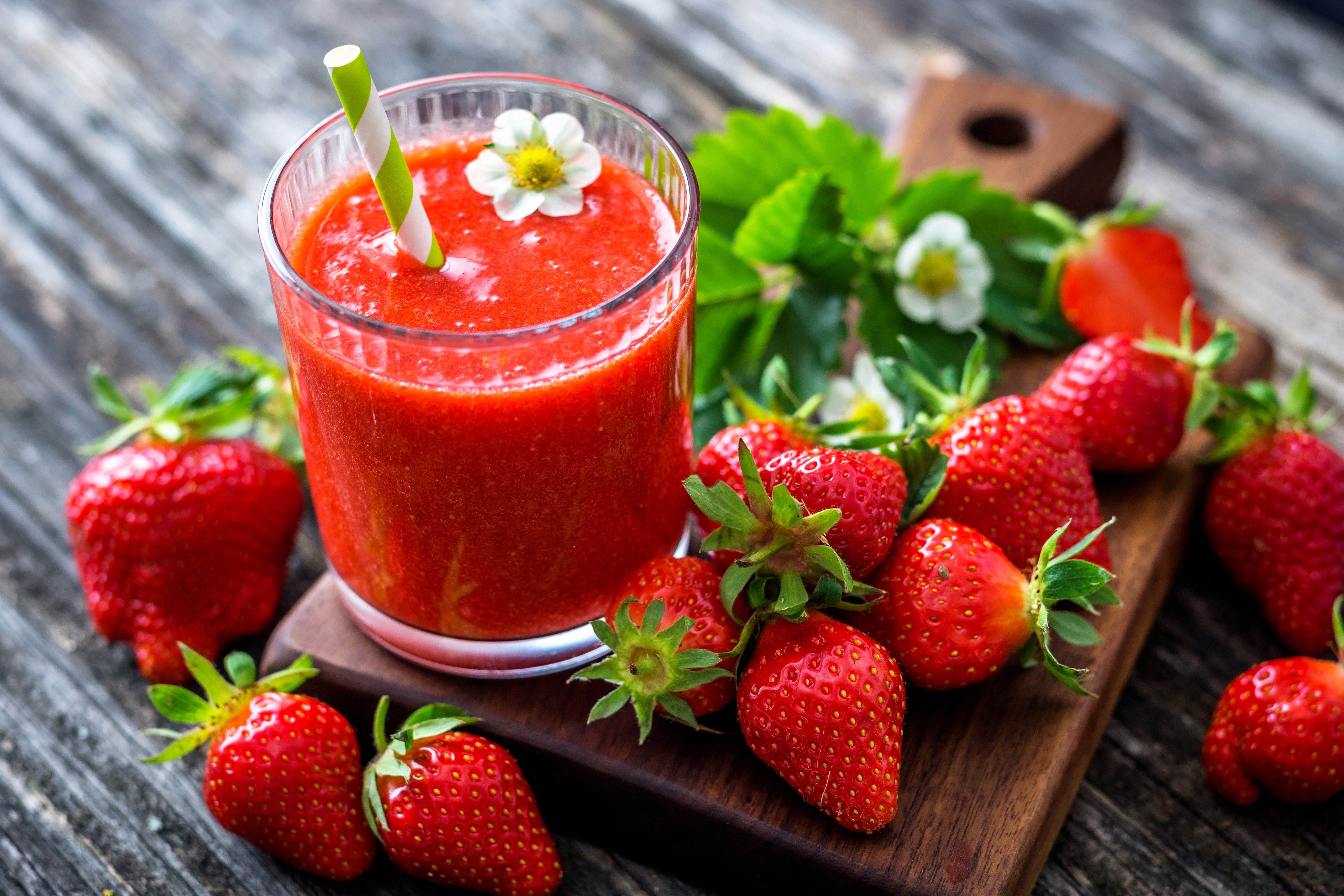 Strawberry juice in a glass with strawberries on a cutting board HD Wallpaper