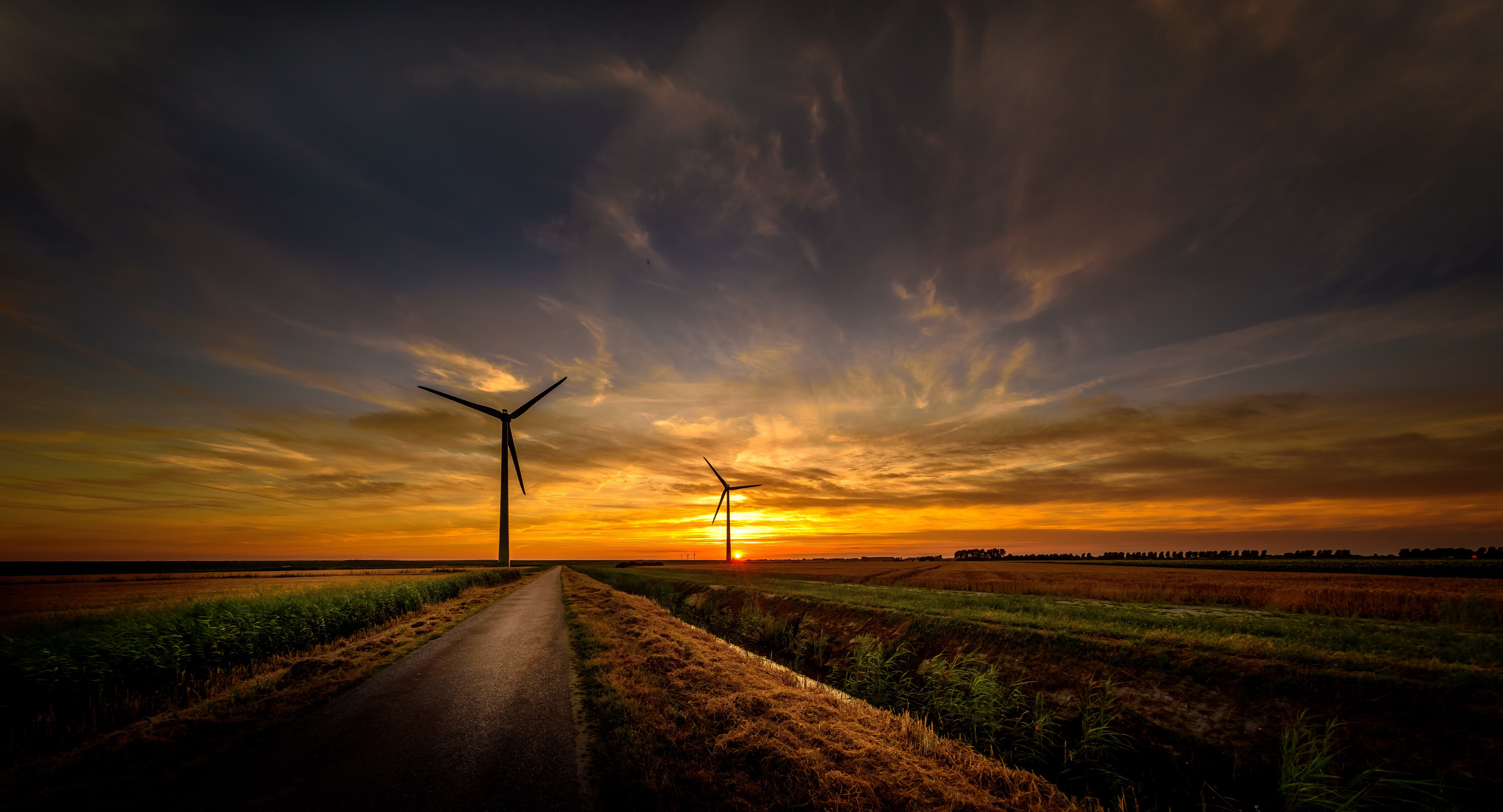 Wind turbines at sunset with a road HD Wallpaper