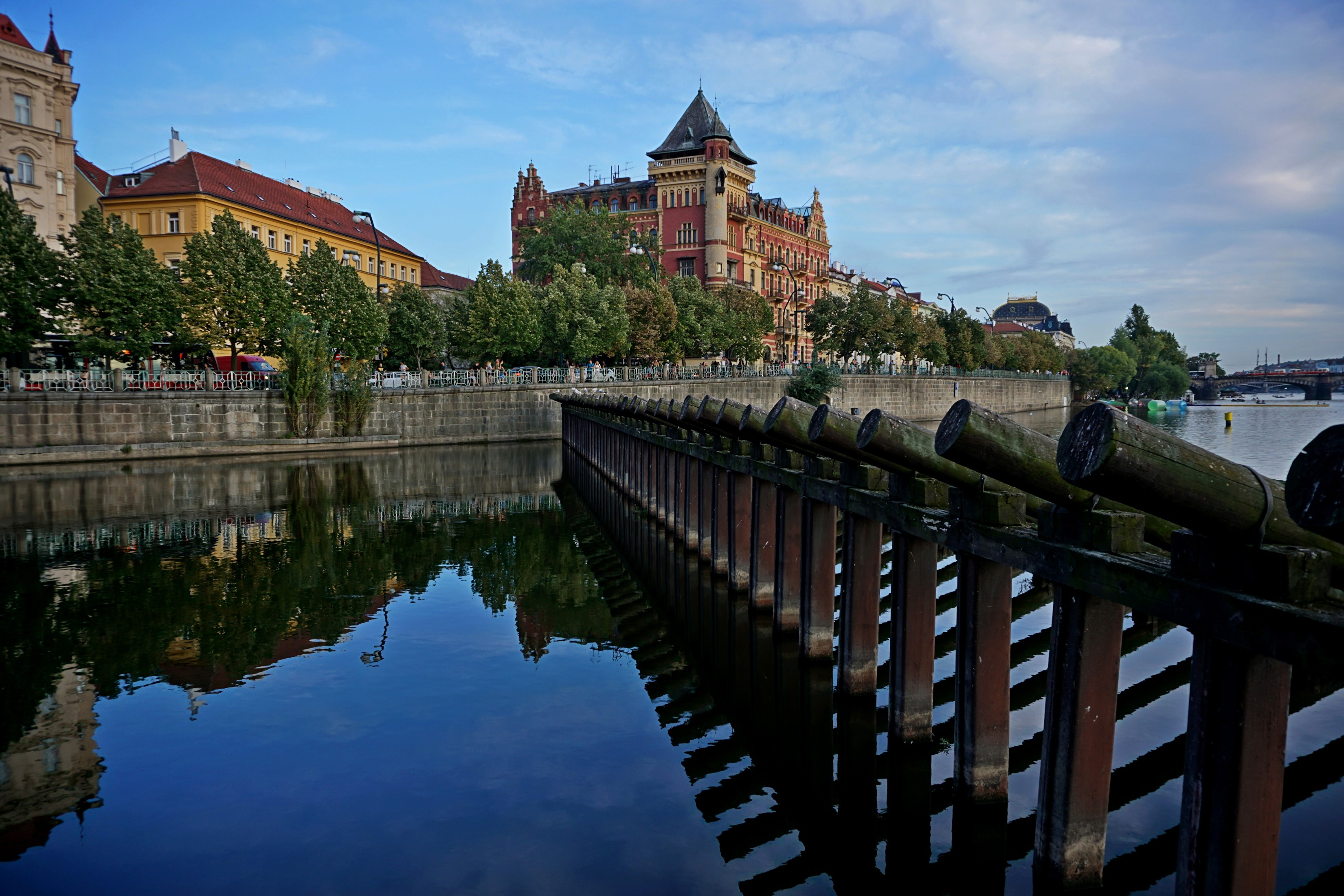 Prague riverfront with historic buildings and wooden fence HD Wallpaper