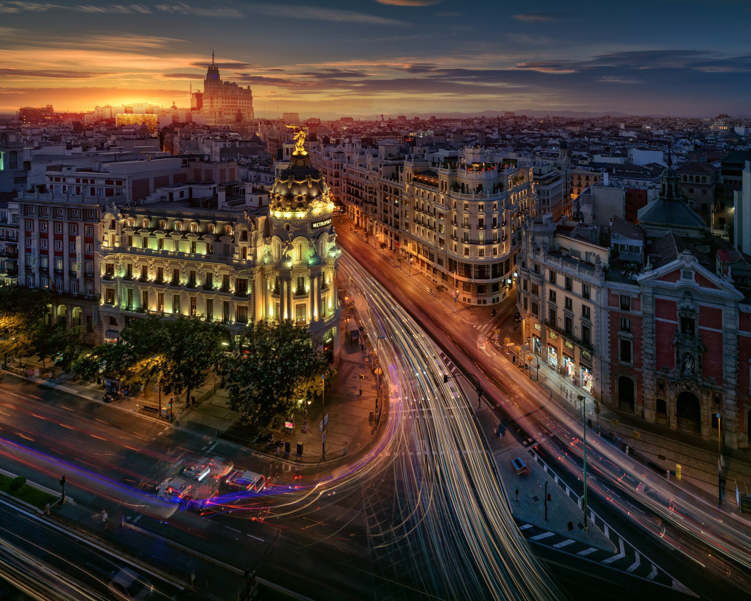 Madrid cityscape at dusk with light trails on roads HD Wallpaper