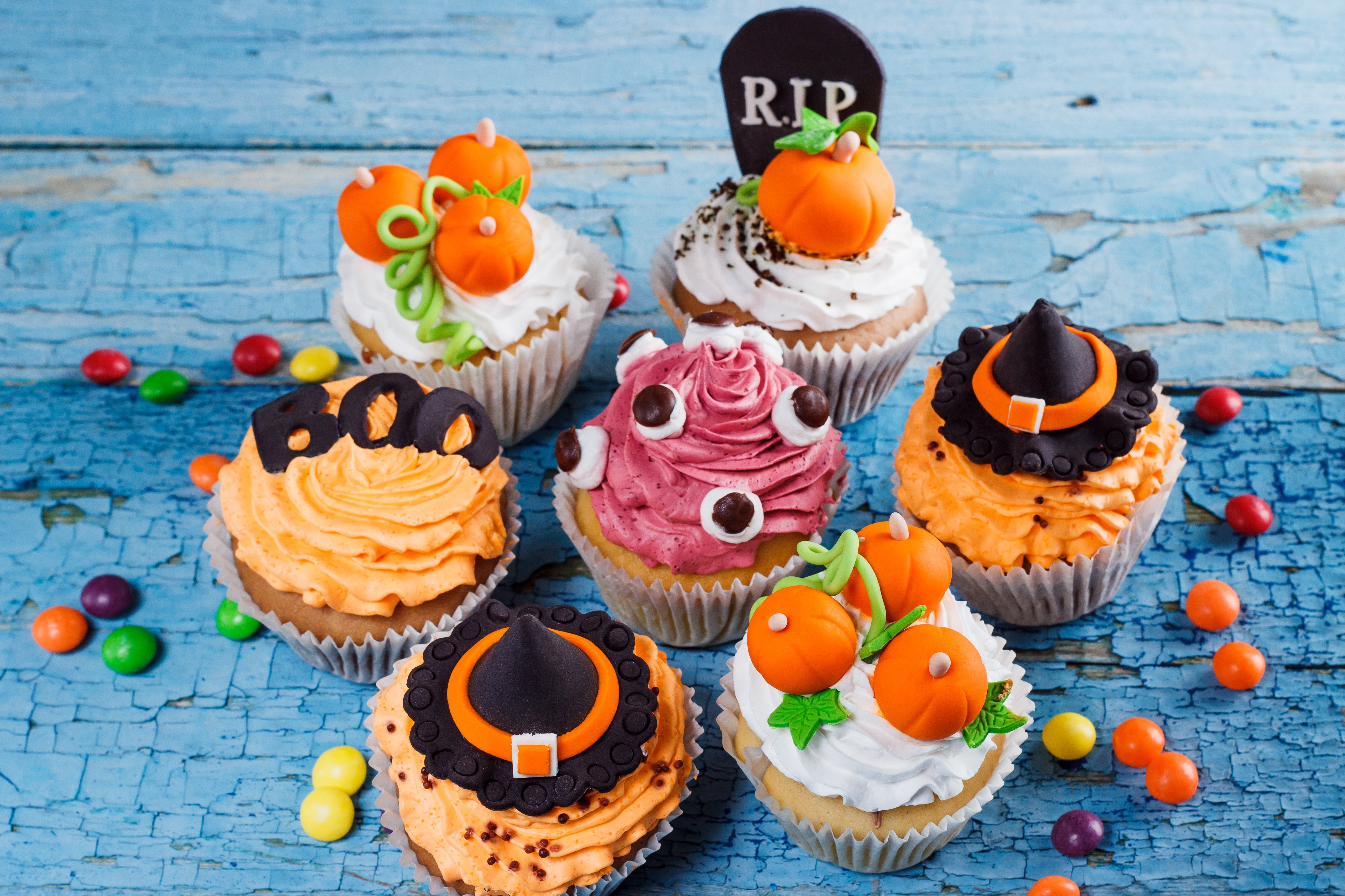 Halloween cupcakes with candy on a blue wooden table HD Wallpaper