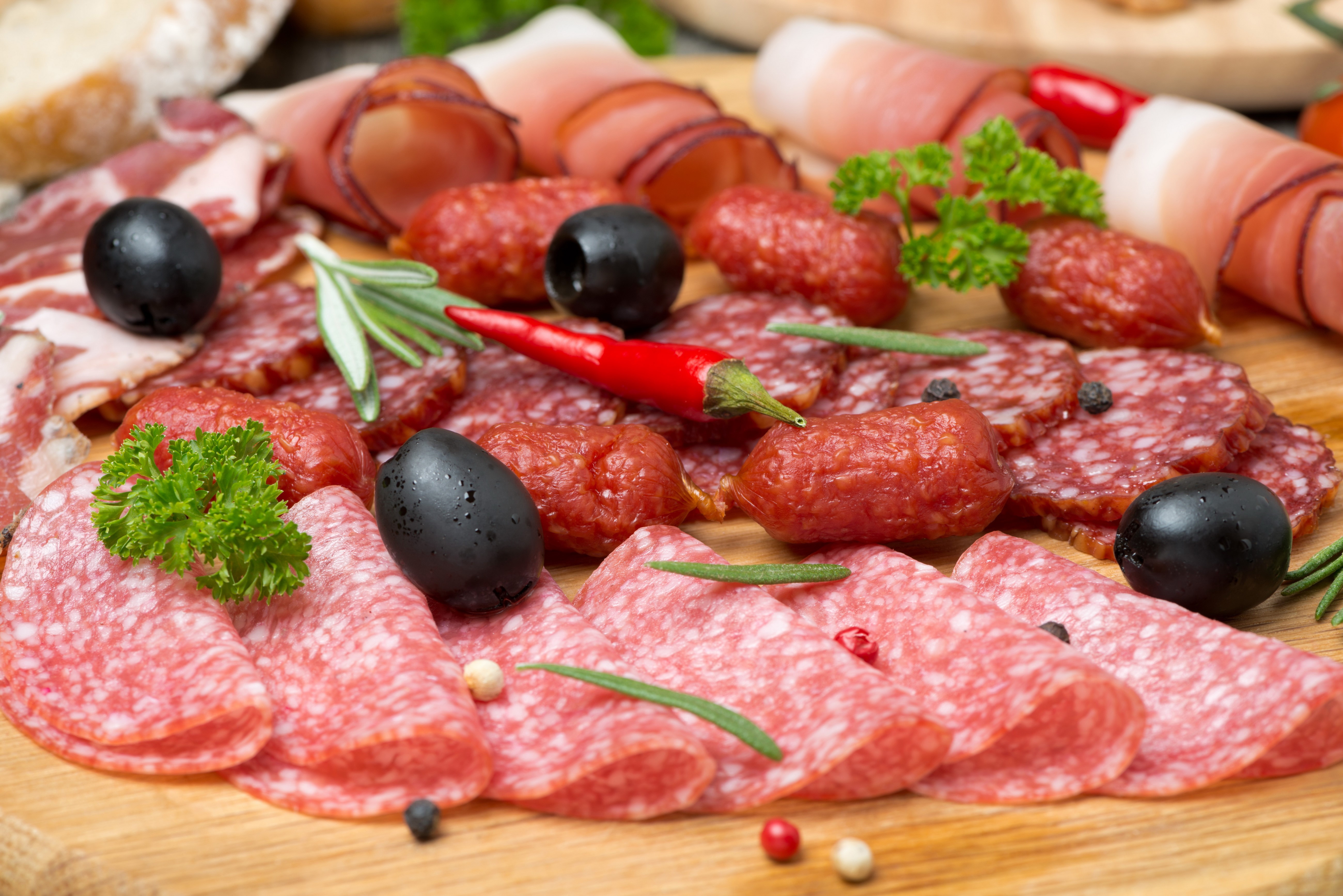 Charcuterie board with cured meats, olives, and chili peppers HD Wallpaper