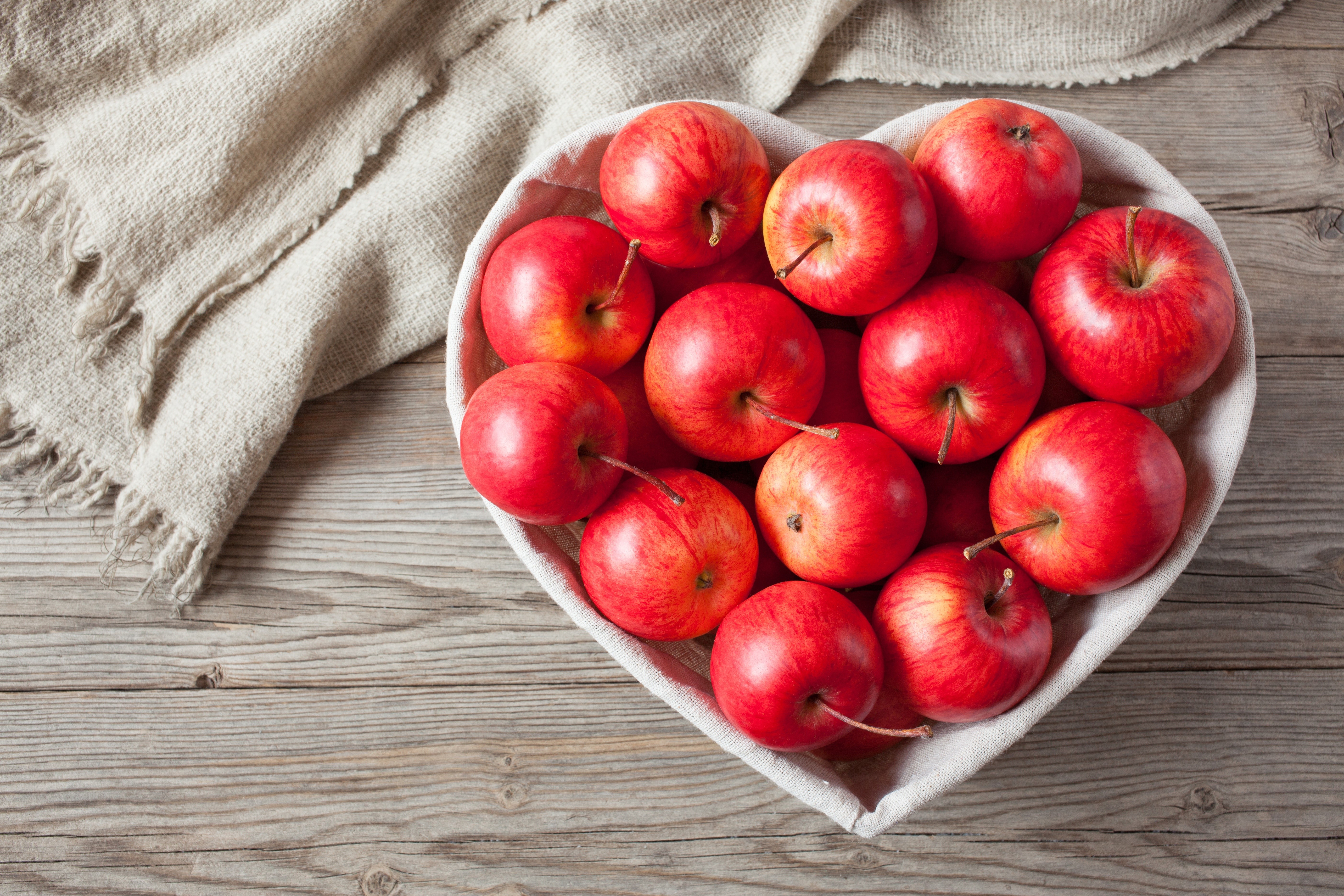 Heart-shaped bowl of red apples HD Wallpaper