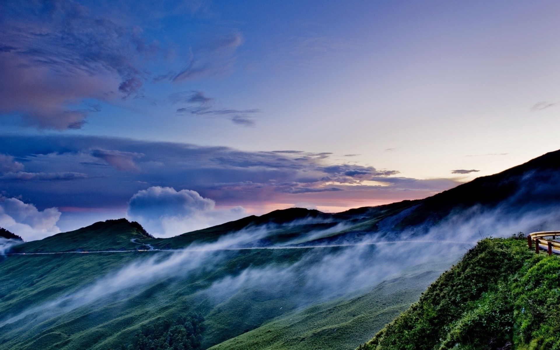 Misty mountains at twilight with a winding road HD Wallpaper