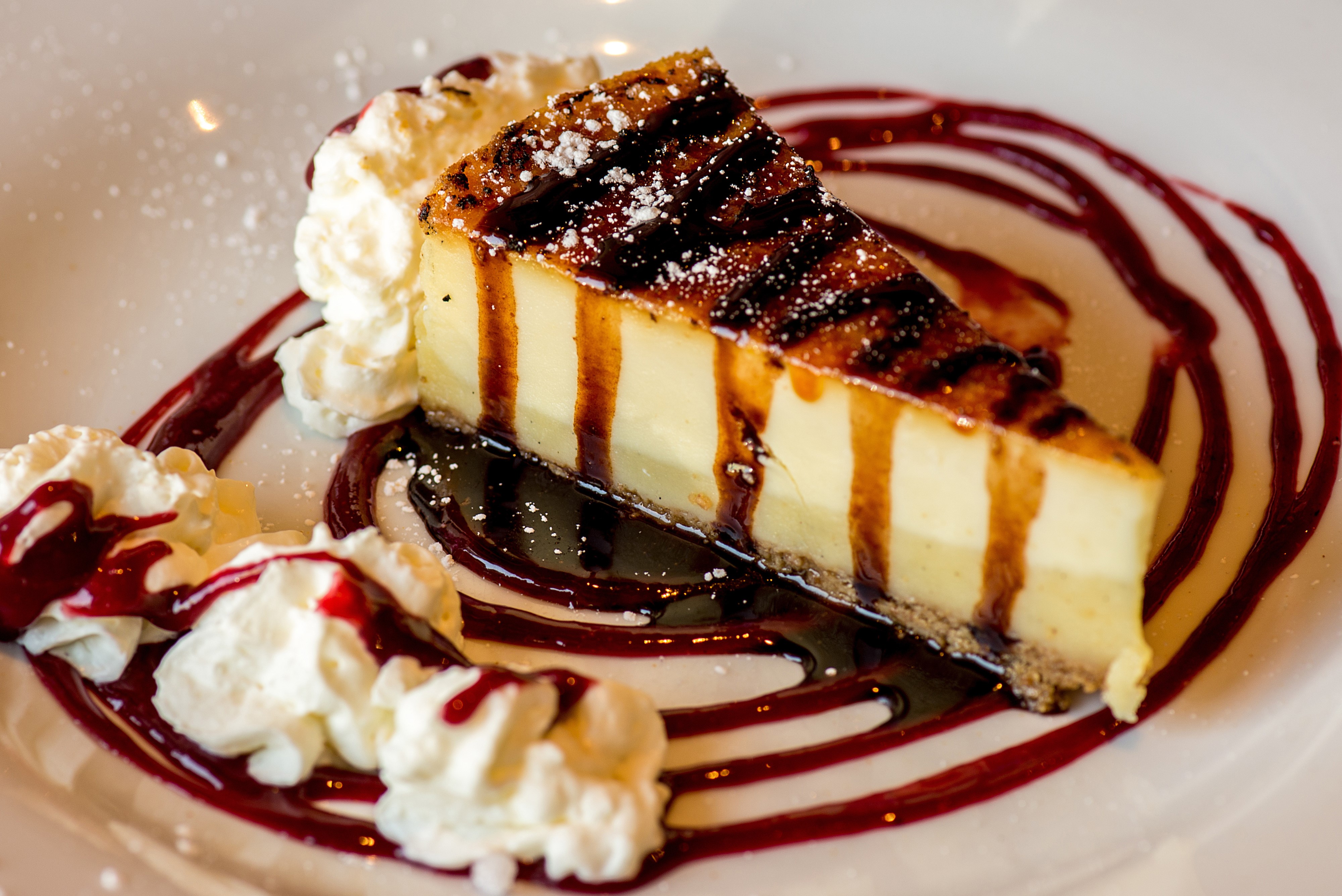 Cheesecake slice with whipped cream and berry sauce HD Wallpaper
