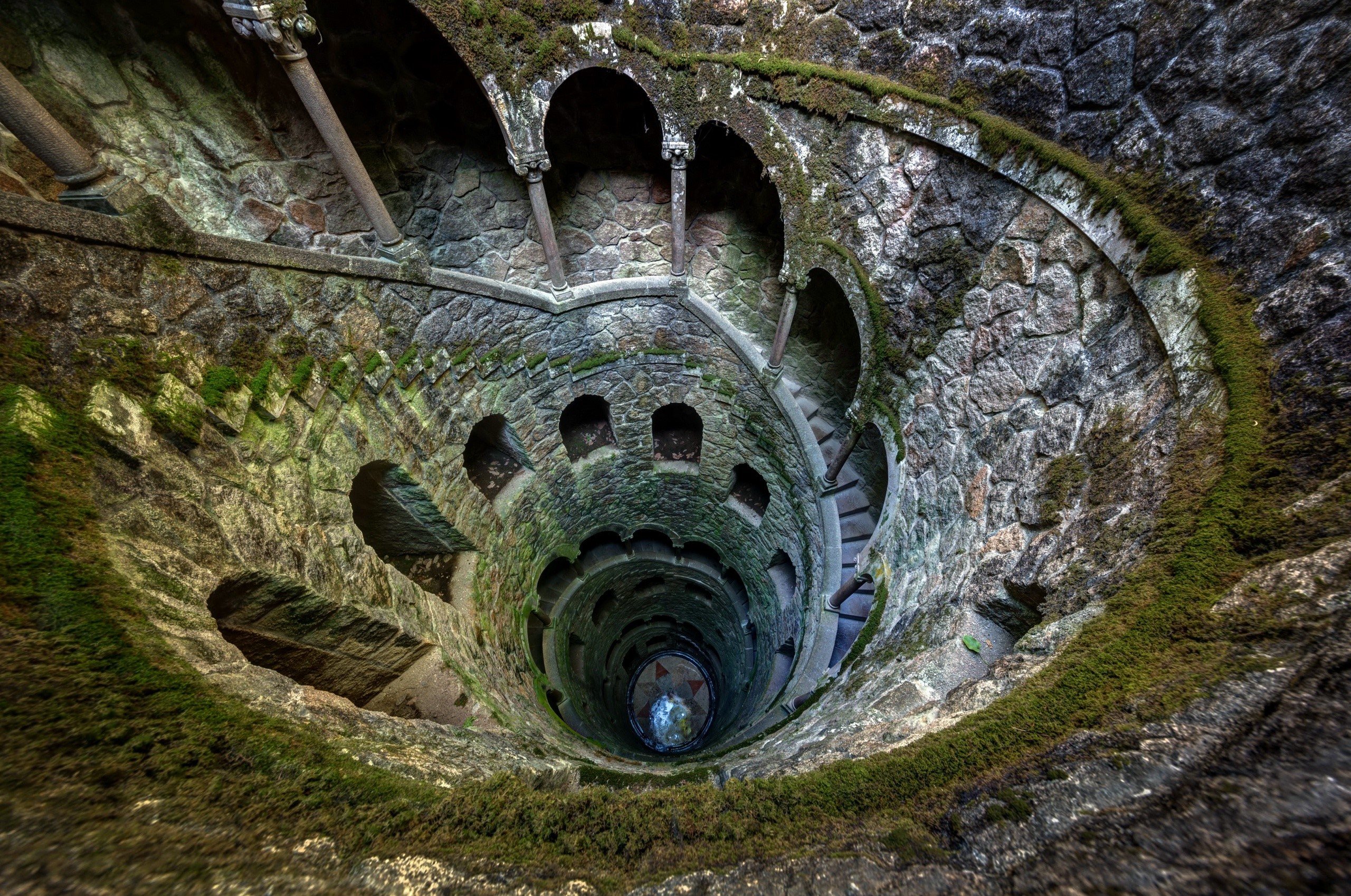 Spiral staircase in a stone well with moss HD Wallpaper