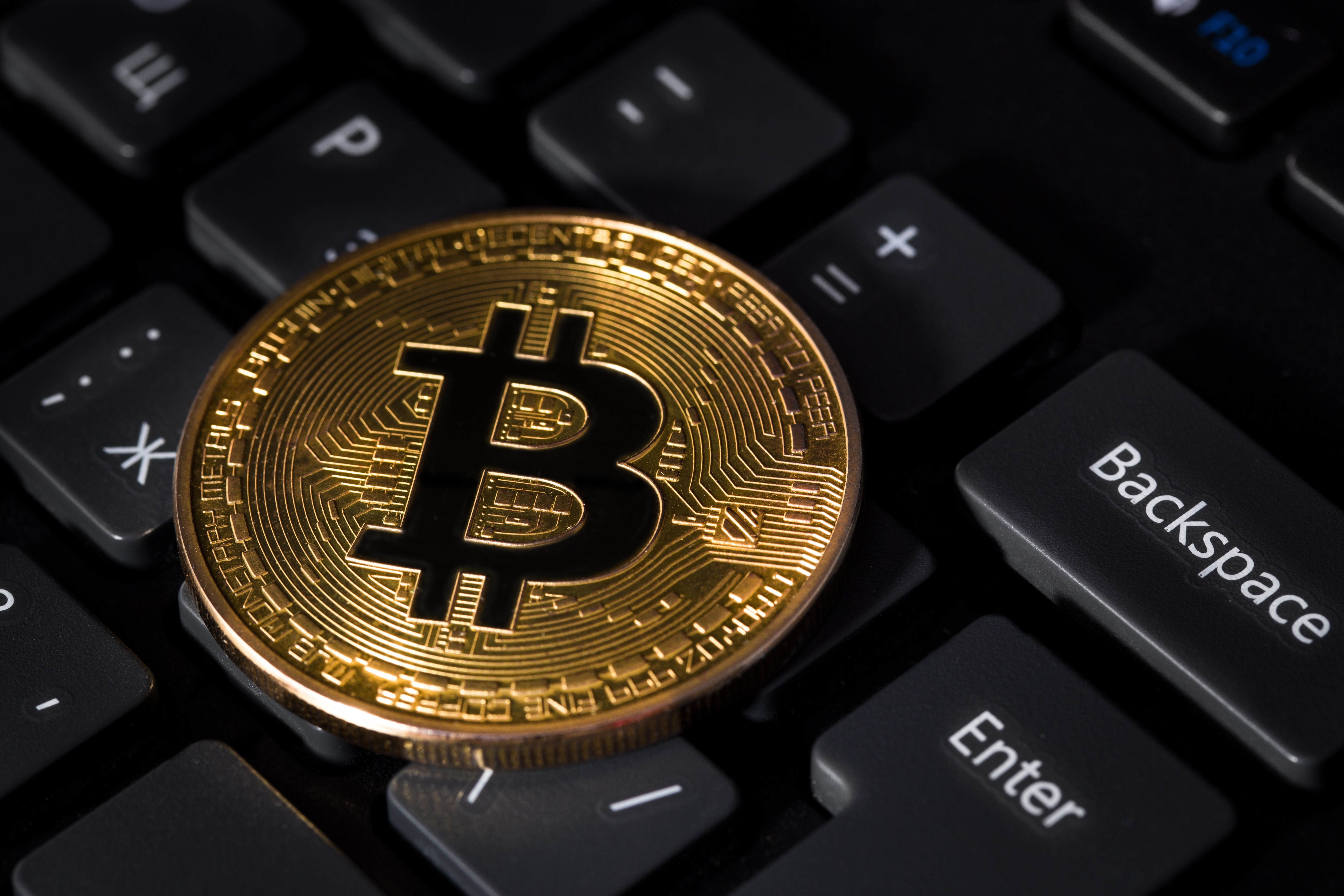 Bitcoin coin on a computer keyboard HD Wallpaper