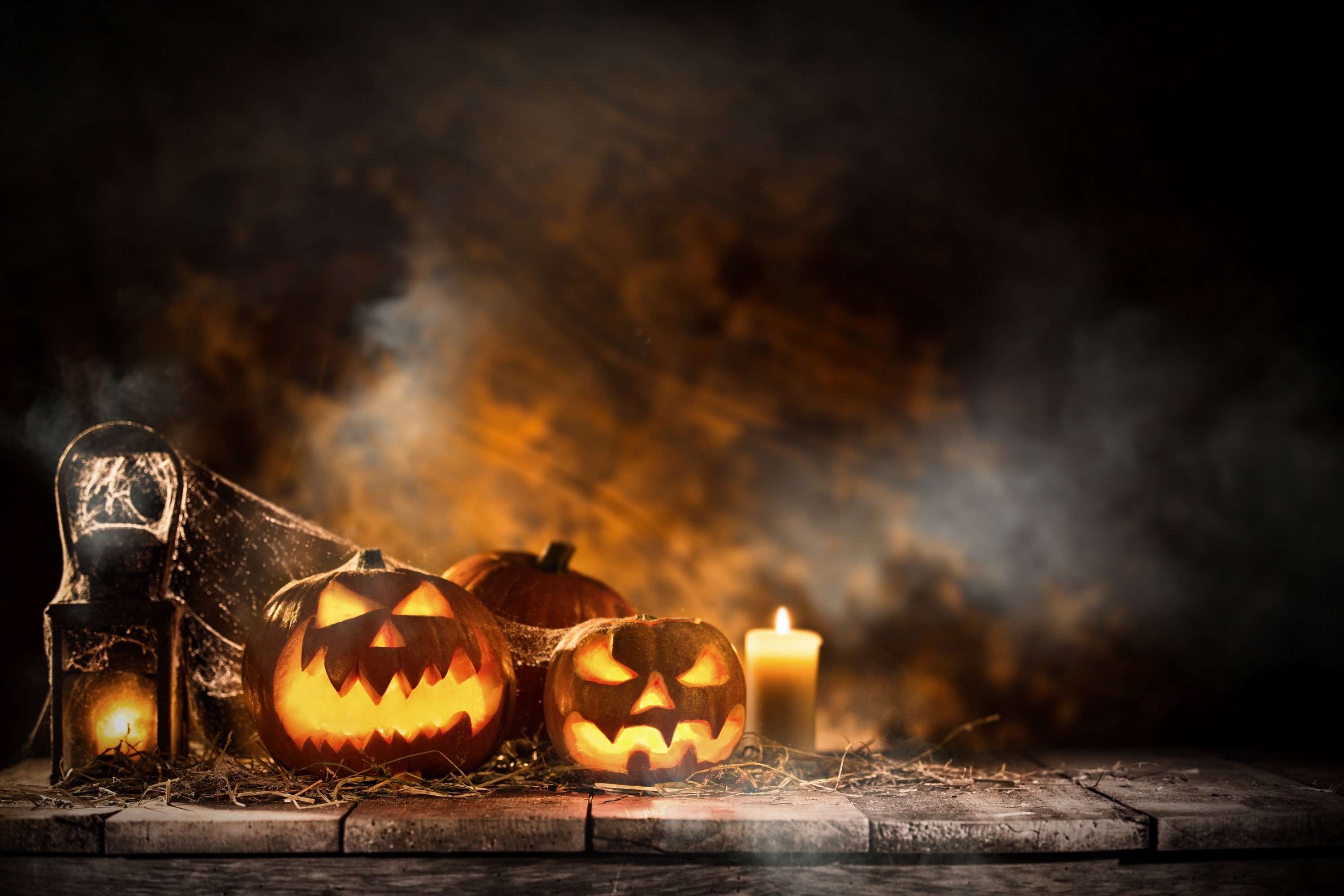 Halloween pumpkins and candle on wooden table HD Wallpaper