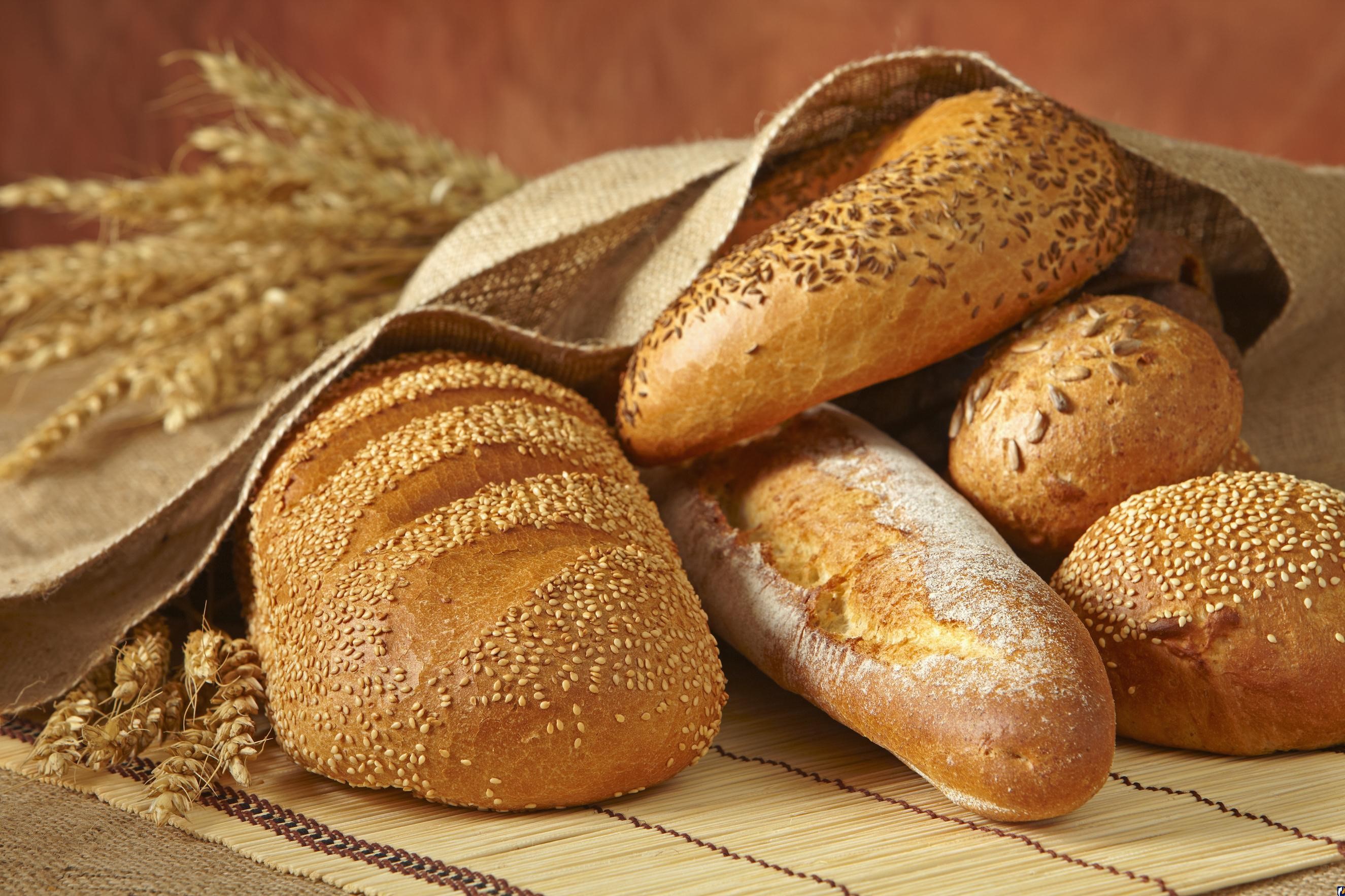 Assortment of freshly baked bread loaves and rolls HD Wallpaper