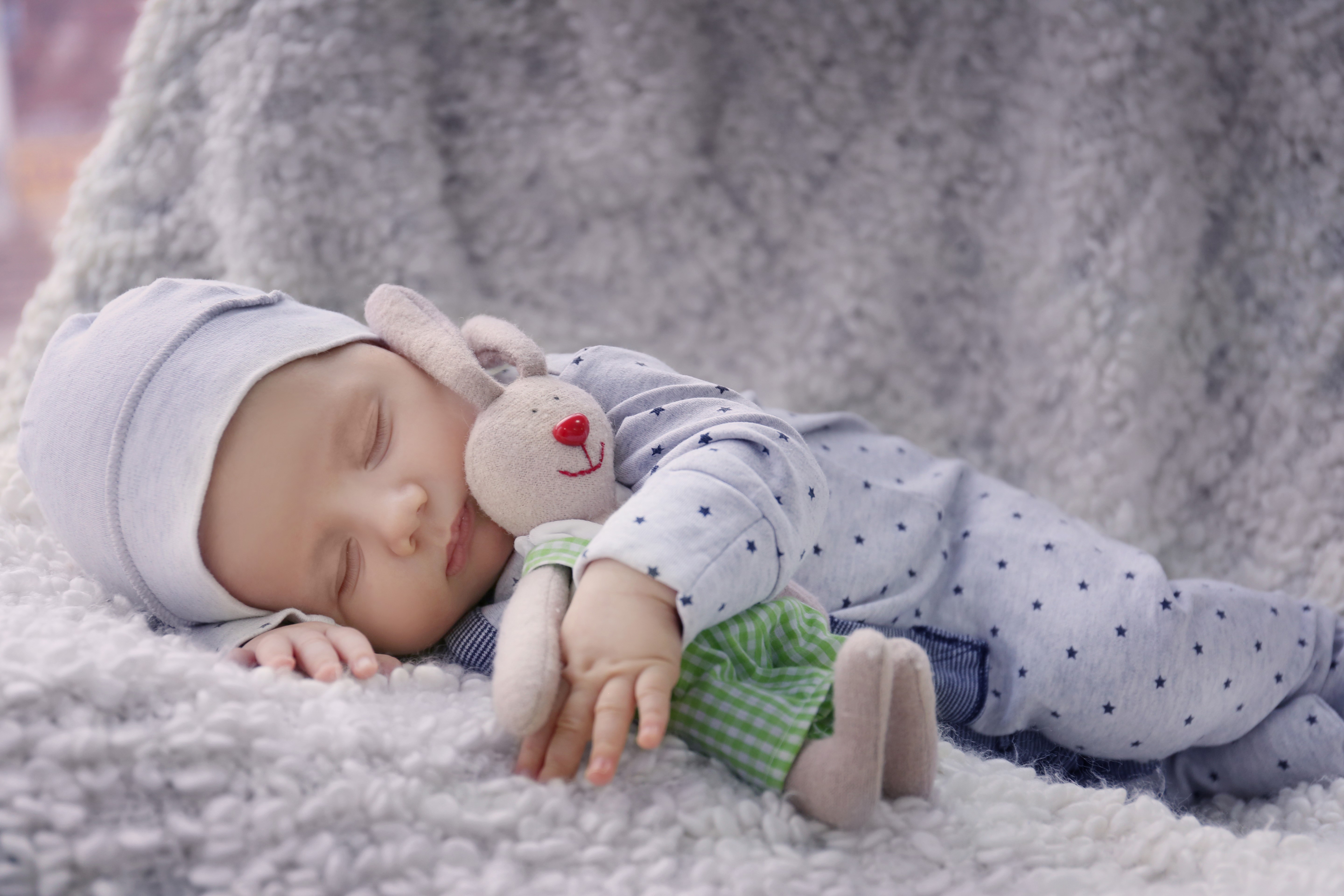 Infant sleeping with a stuffed rabbit toy HD Wallpaper