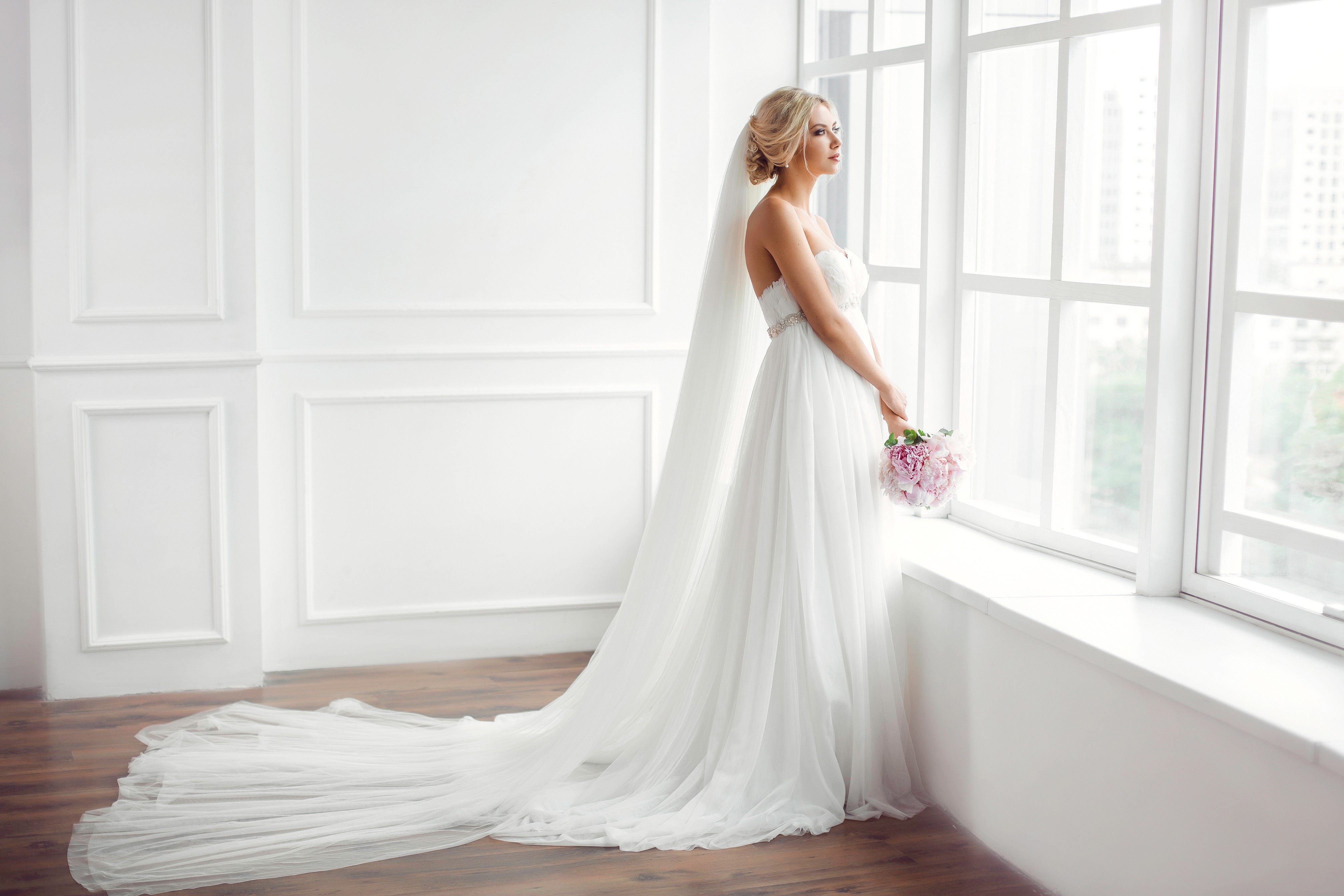 Bride in a white dress with a bouquet by the window HD Wallpaper