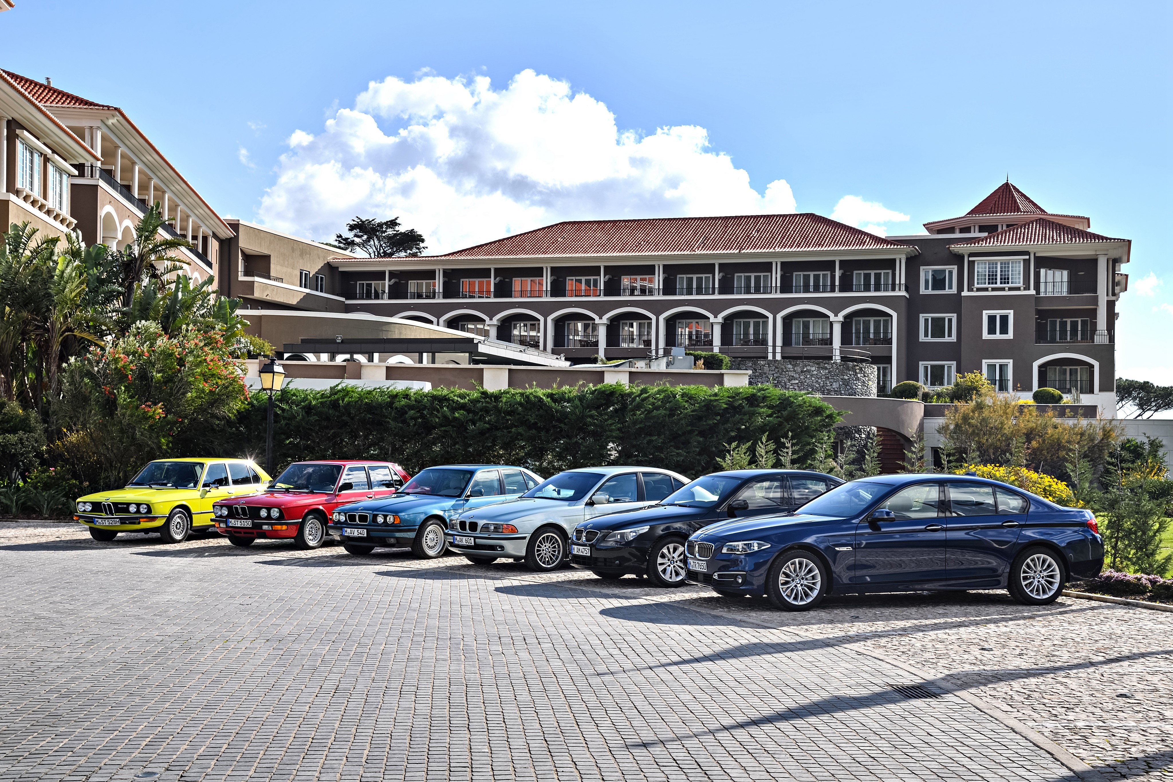 BMW 5 Series cars parked in front of a hotel HD Wallpaper