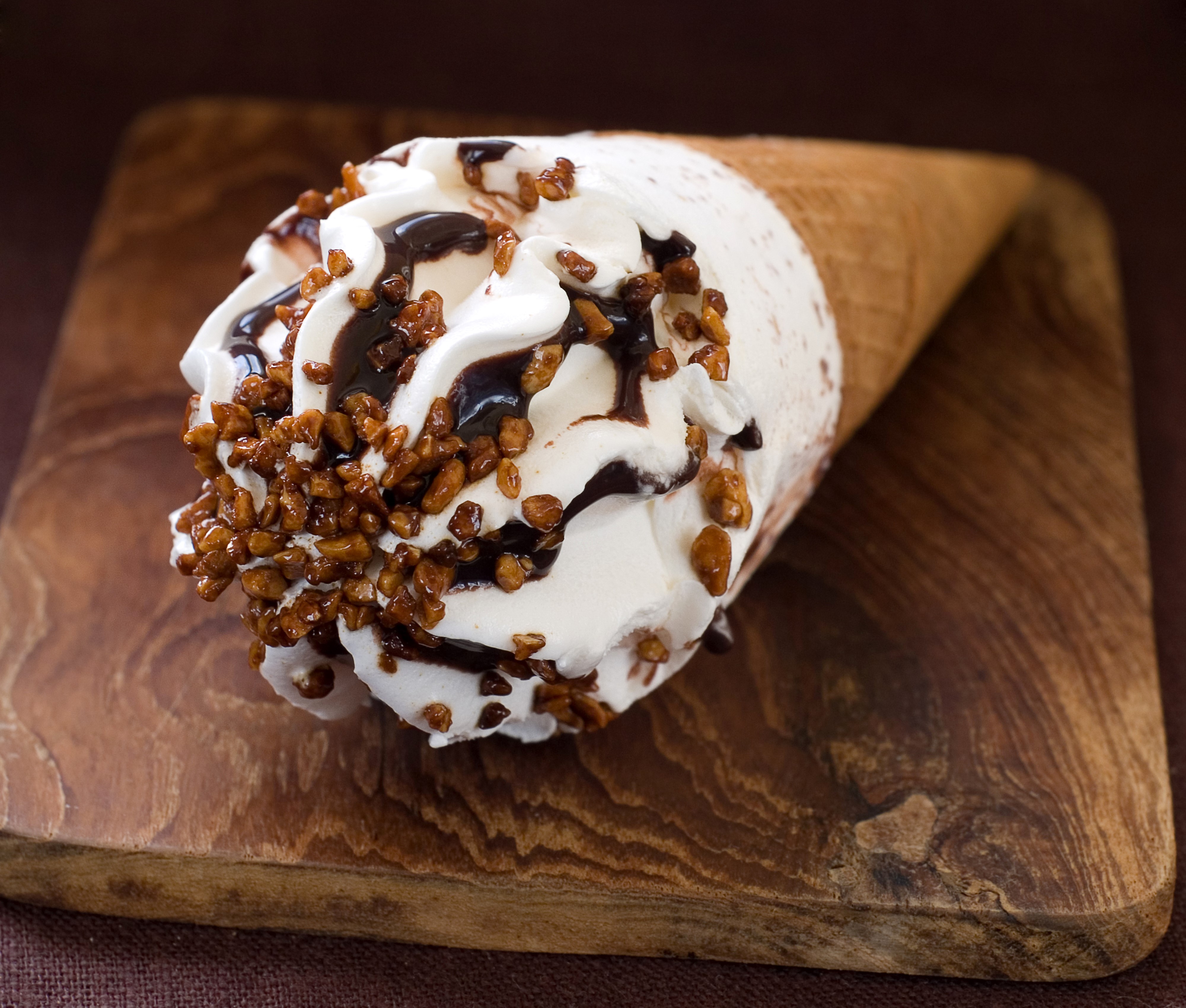 Ice cream cone with chocolate and nuts on cutting board HD Wallpaper