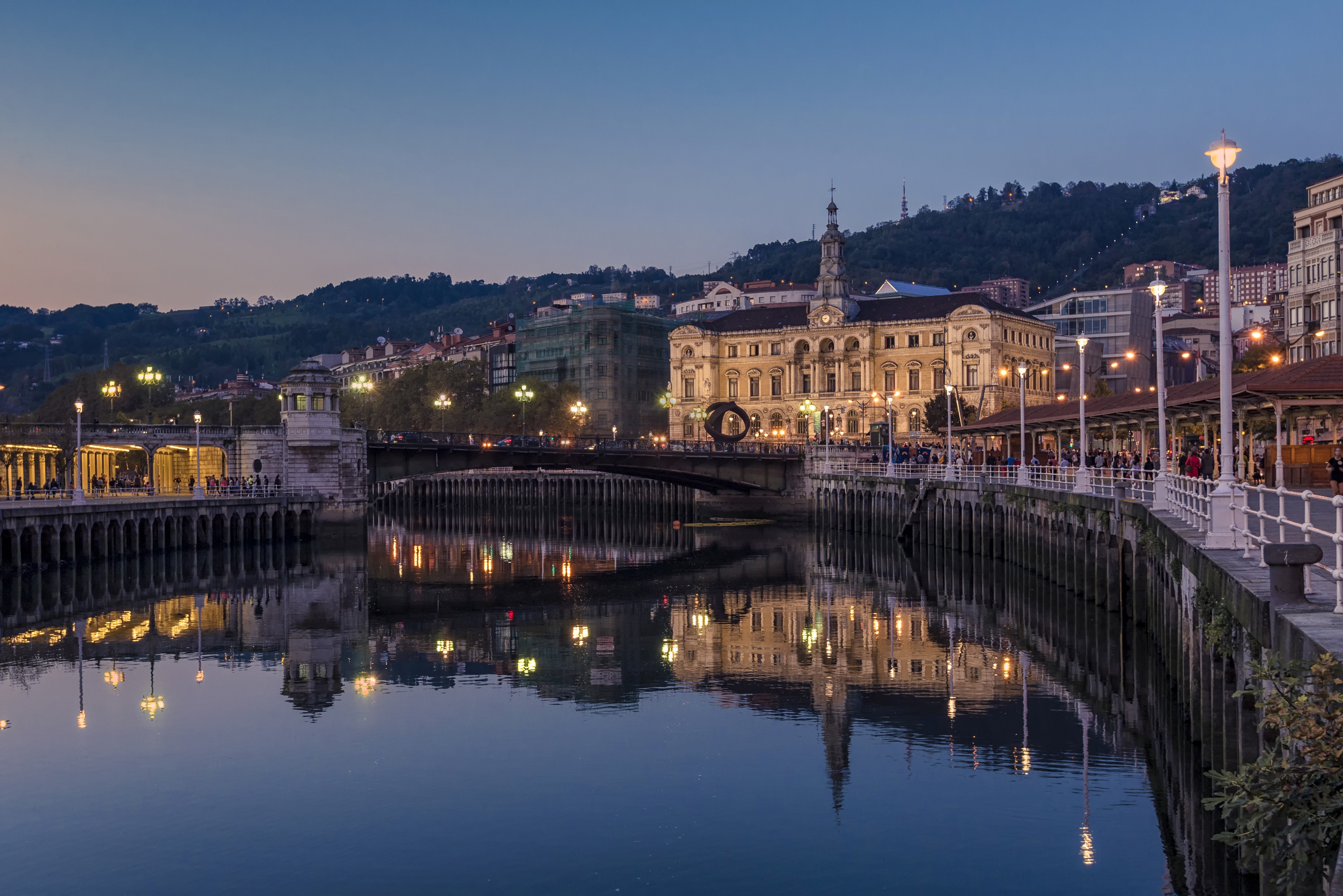 Bilbao riverfront with buildings and bridge at dusk HD Wallpaper