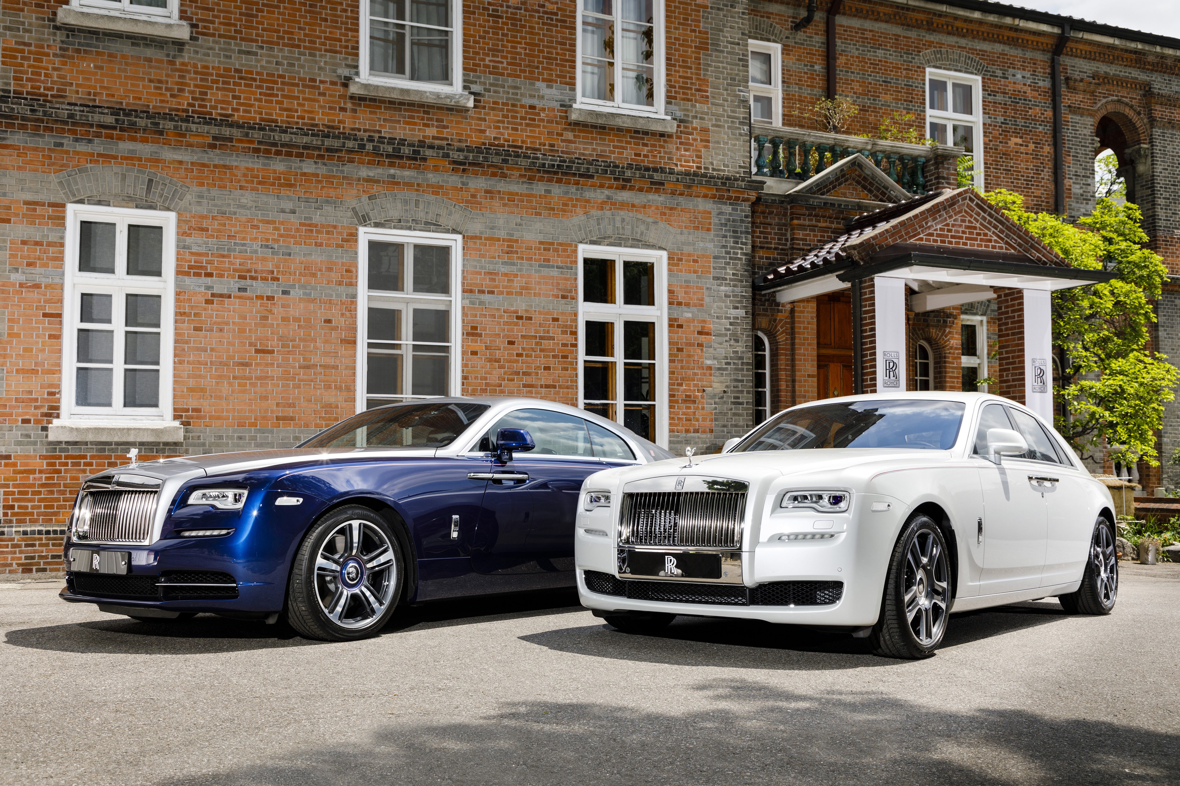 Two Rolls-Royce cars in front of a brick building HD Wallpaper