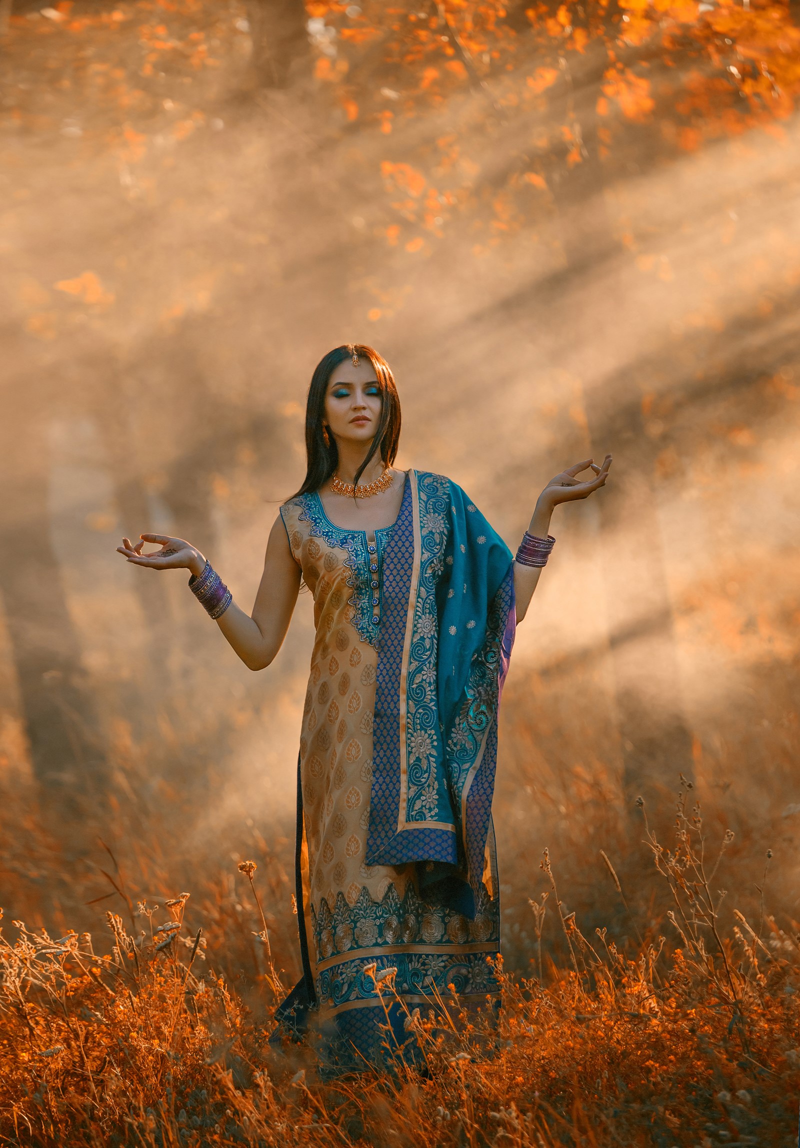 Woman in traditional Indian clothing meditating in autumn field HD Phone Wallpaper