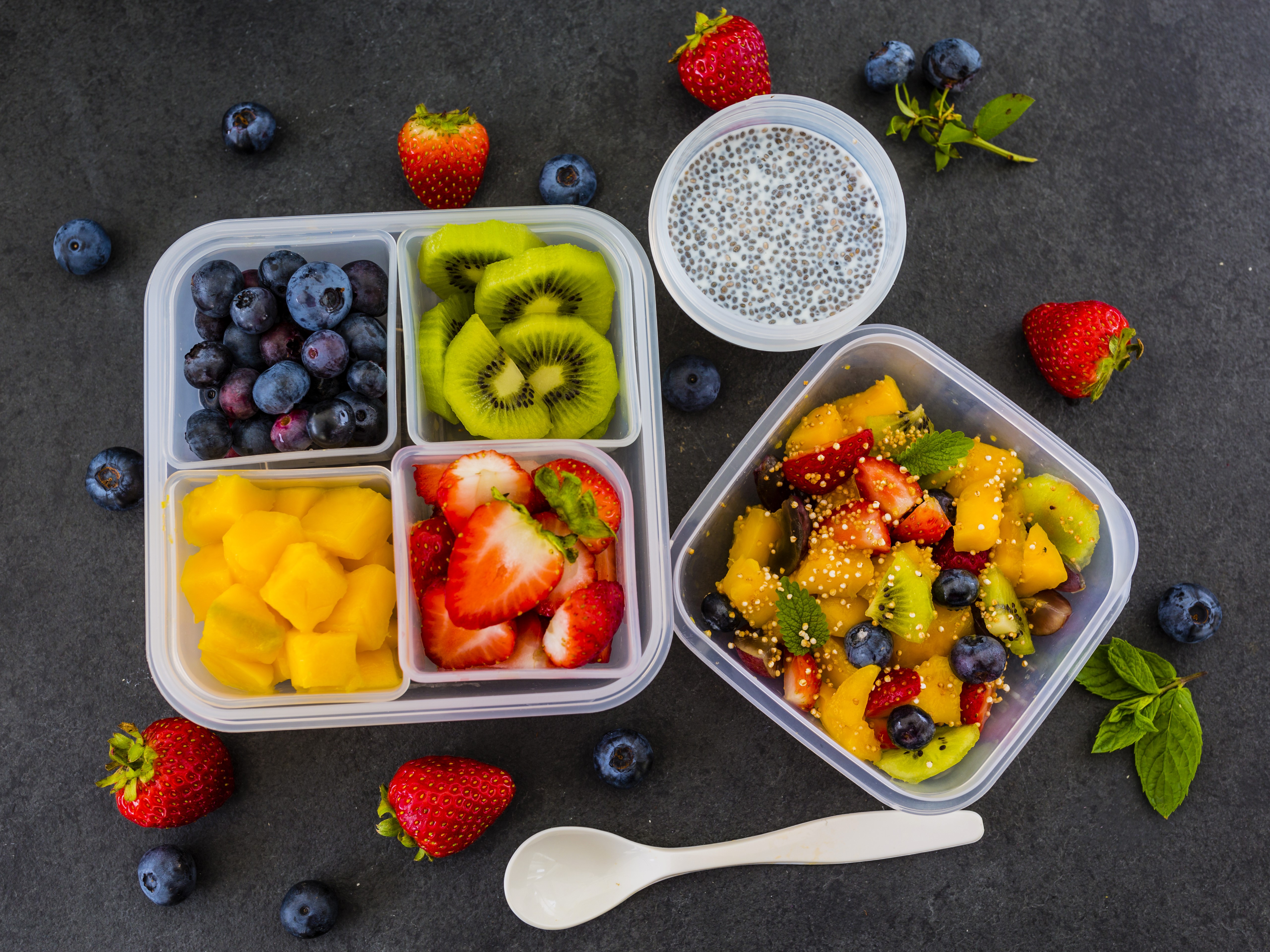 Fruit salad with blueberries, strawberries, kiwi, and mango in a lunchbox HD Wallpaper