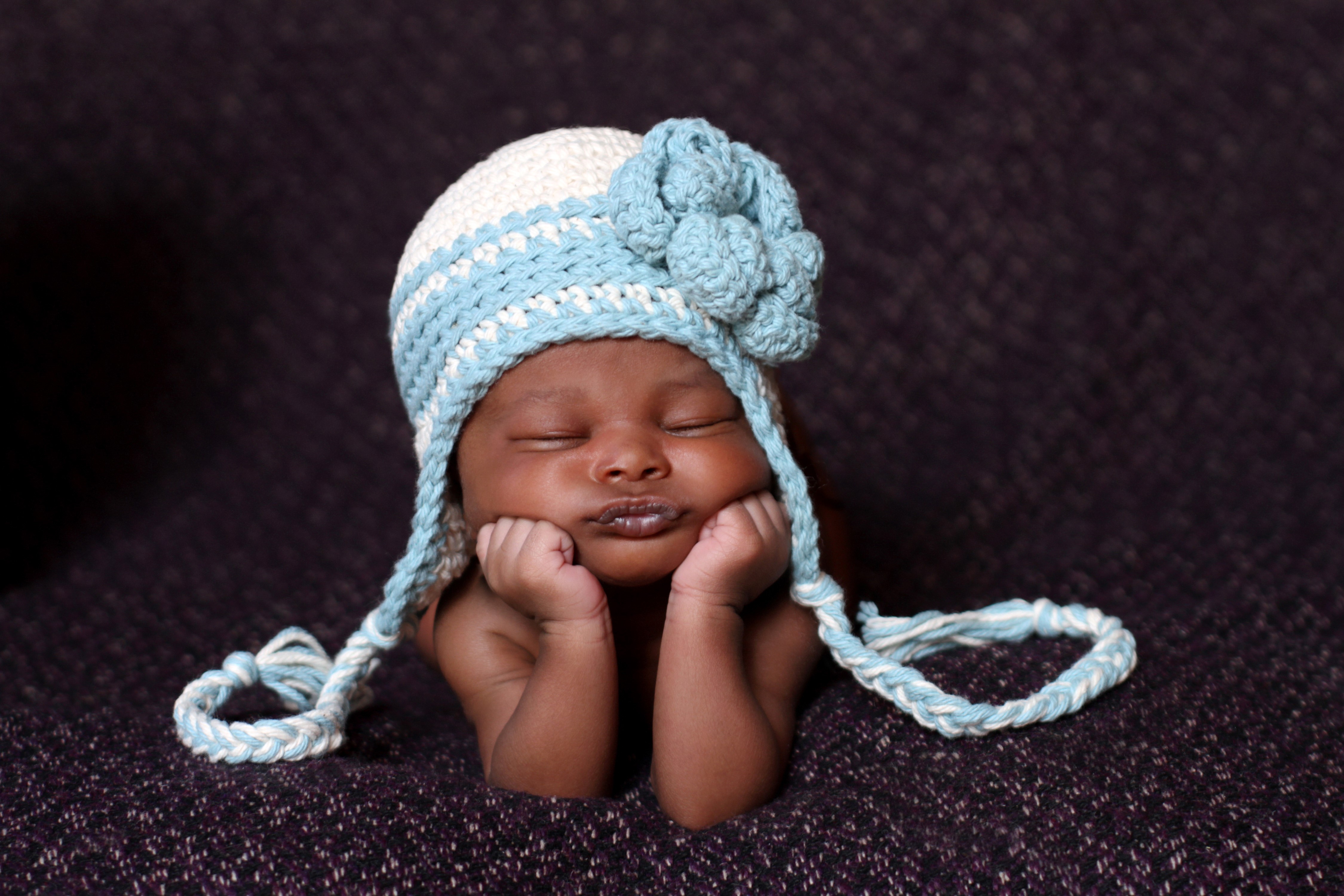 Baby wearing a blue and white knitted hat HD Wallpaper