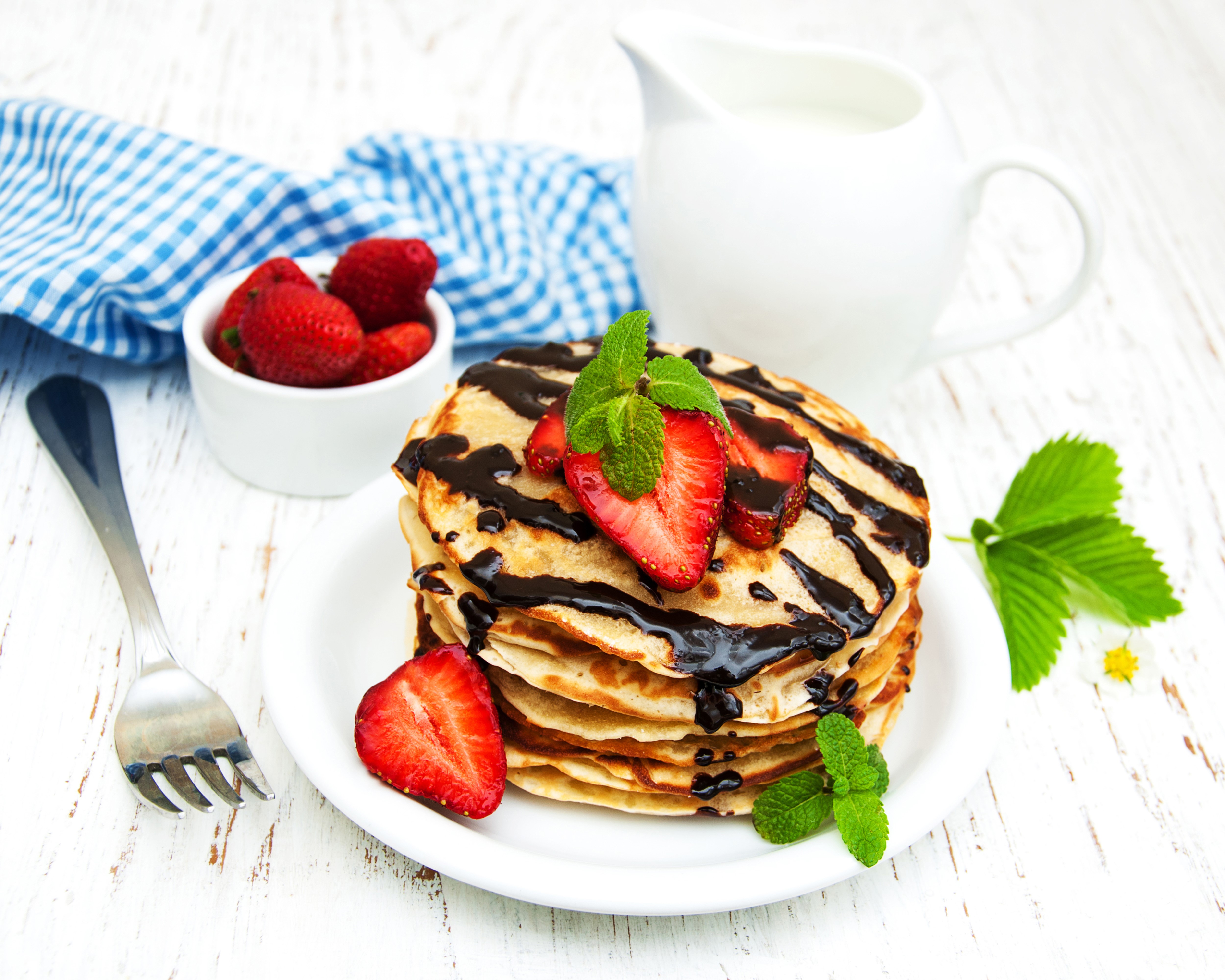 Pancakes with chocolate, strawberries, and mint on a plate with a fork HD Wallpaper
