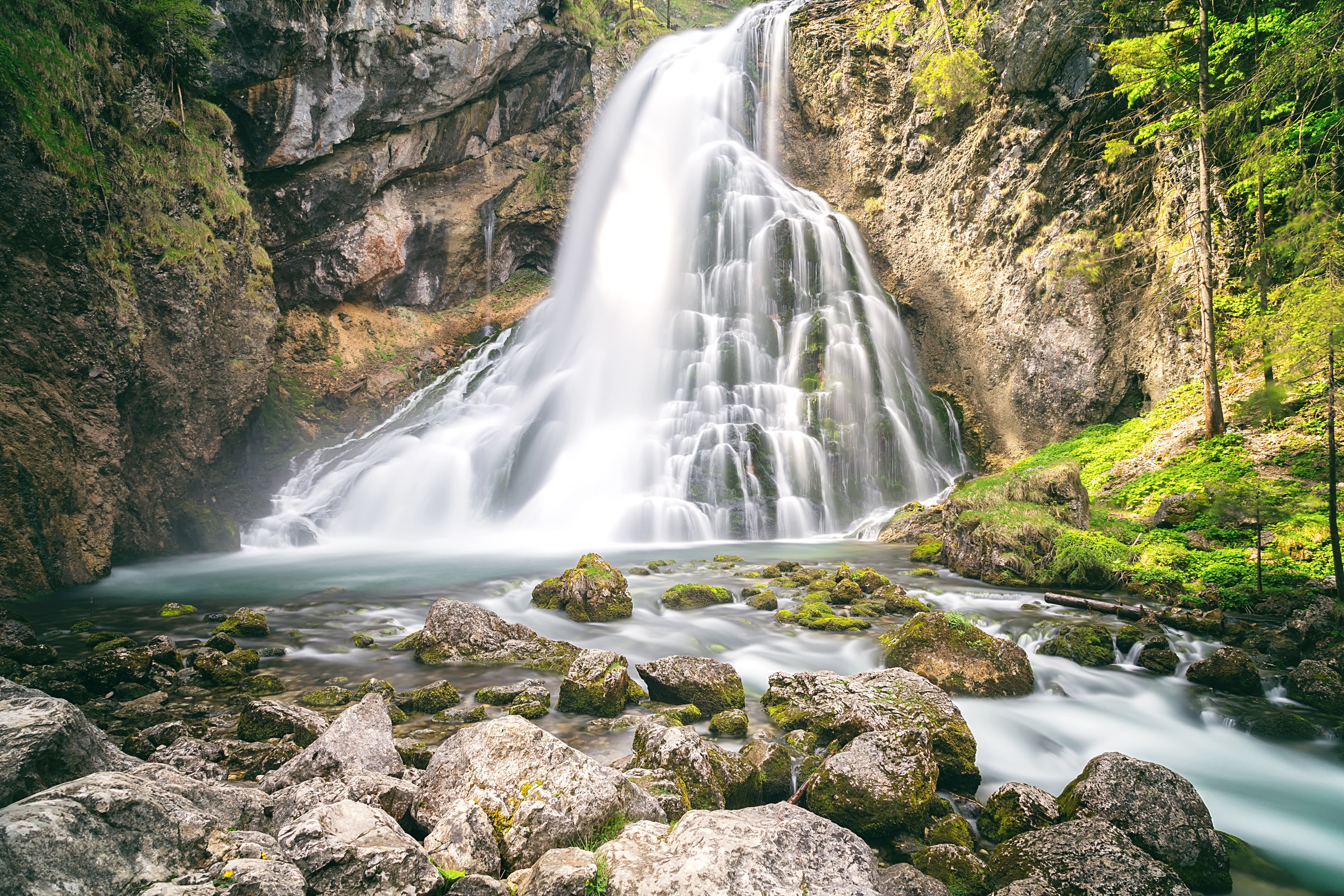 Waterfall cascading over mossy rocks and cliffs HD Wallpaper