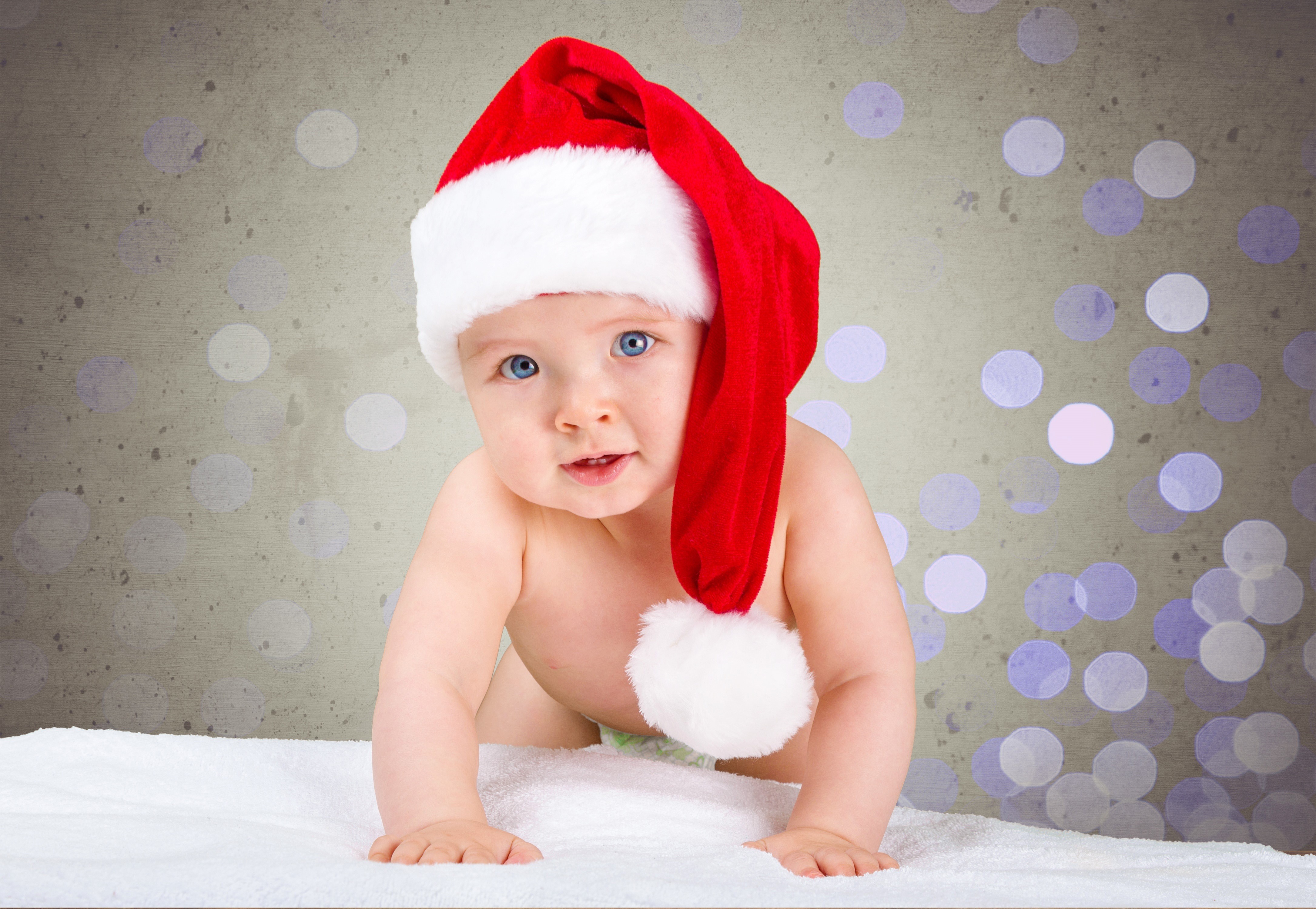Baby in Santa hat crawling on white blanket HD Wallpaper