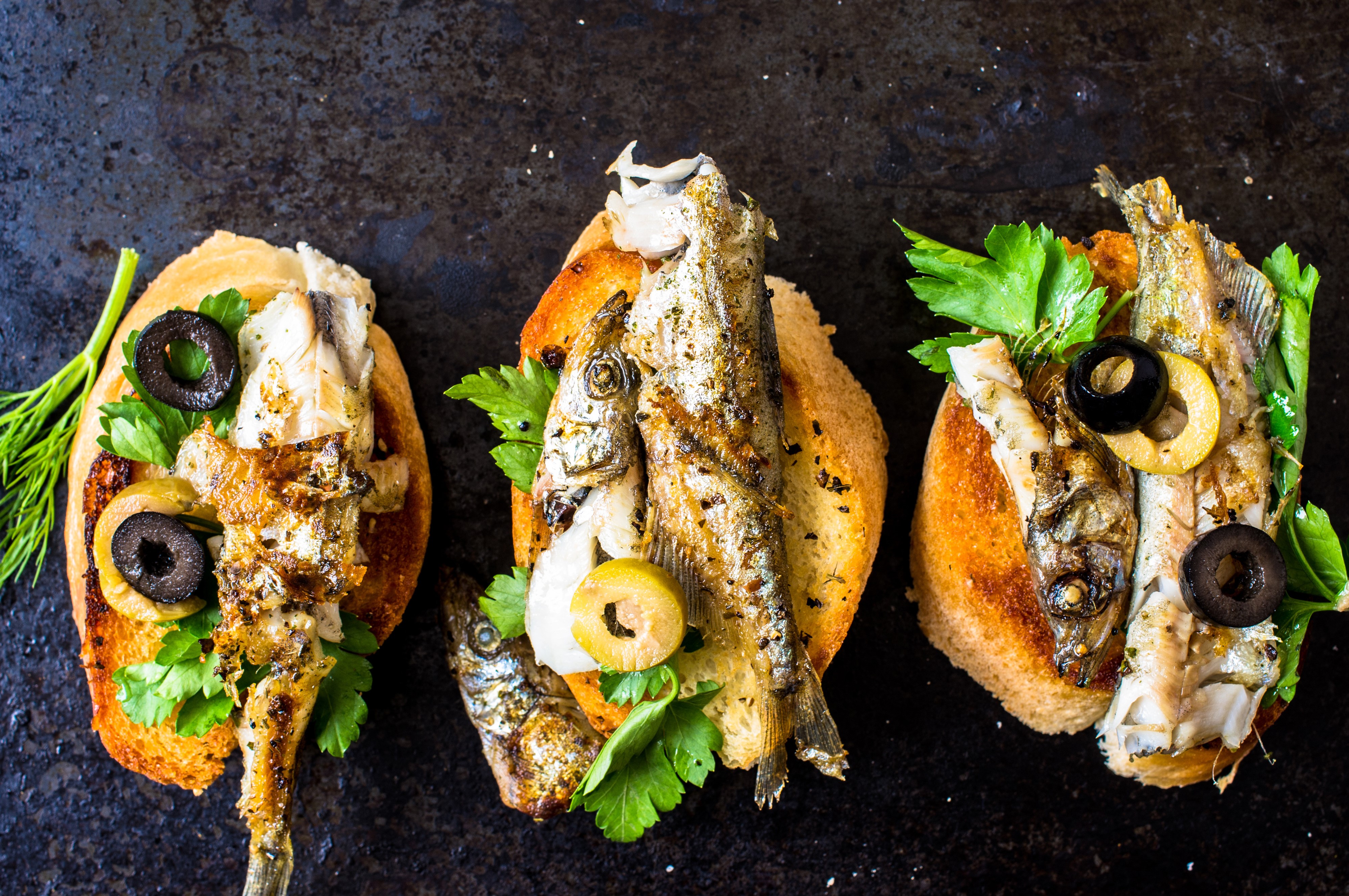 Toasted bread with grilled fish and olives HD Wallpaper