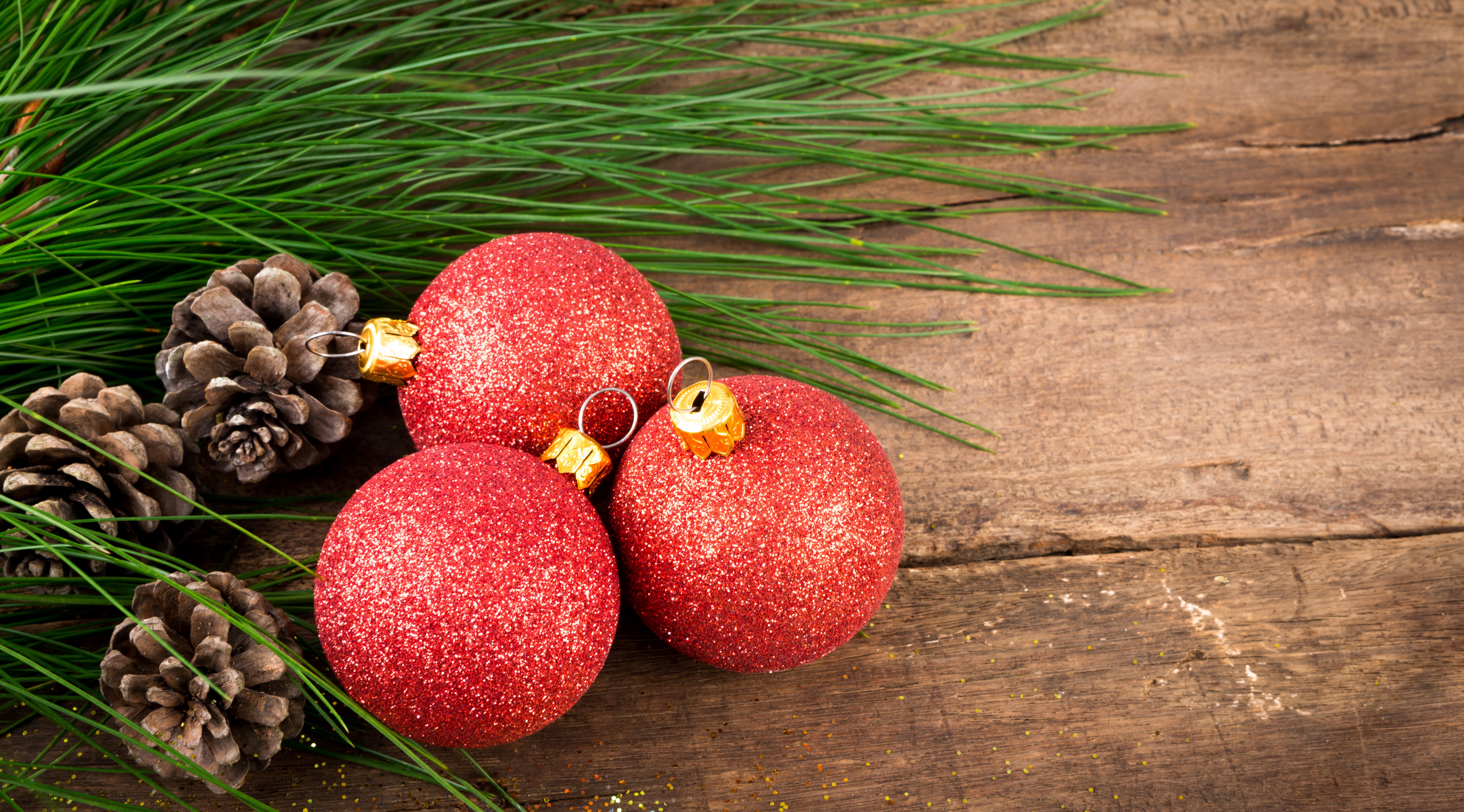 Christmas pine cones and red ornaments on wood HD Wallpaper