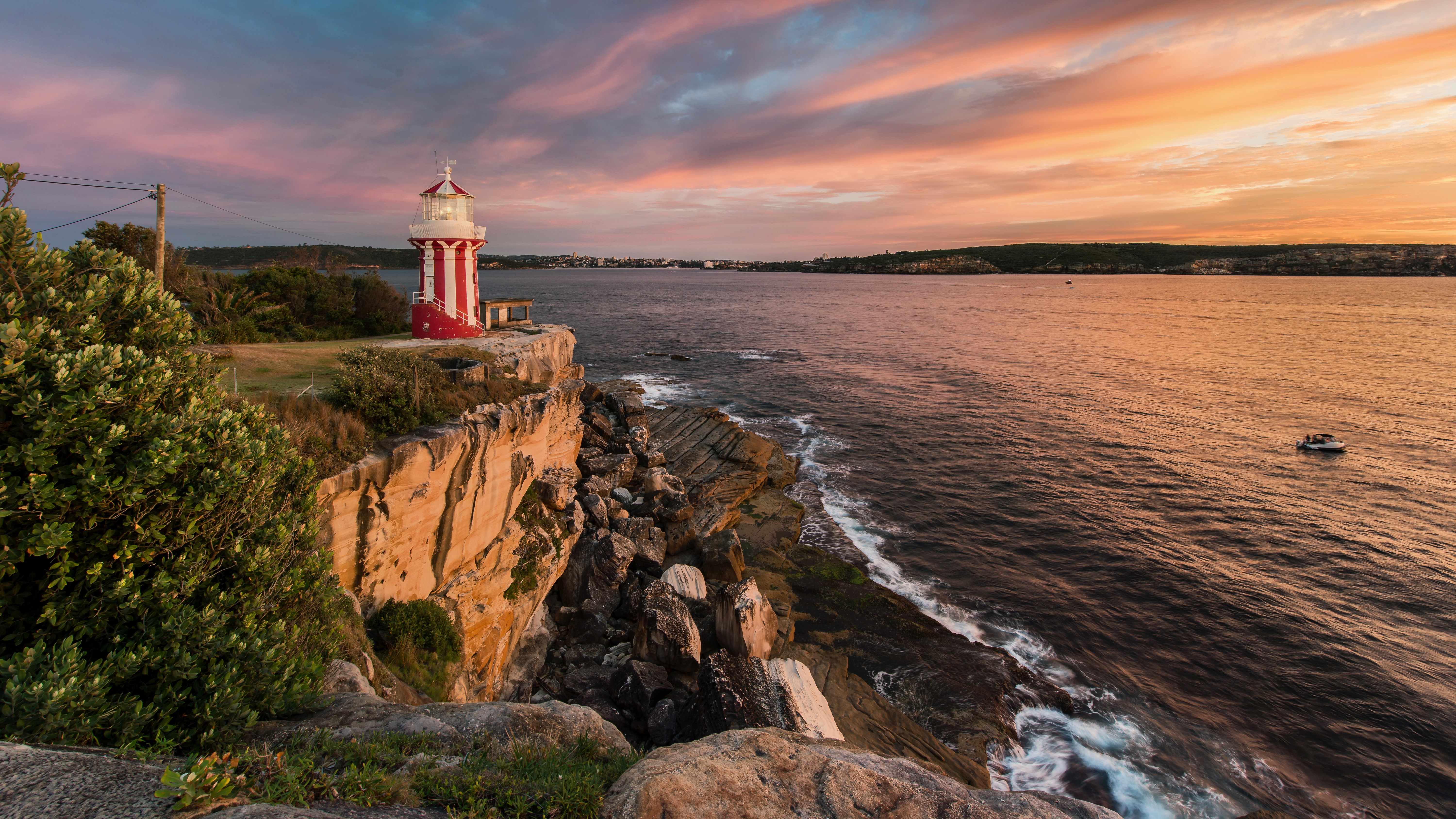 Red and white lighthouse on a cliff at sunset HD Wallpaper