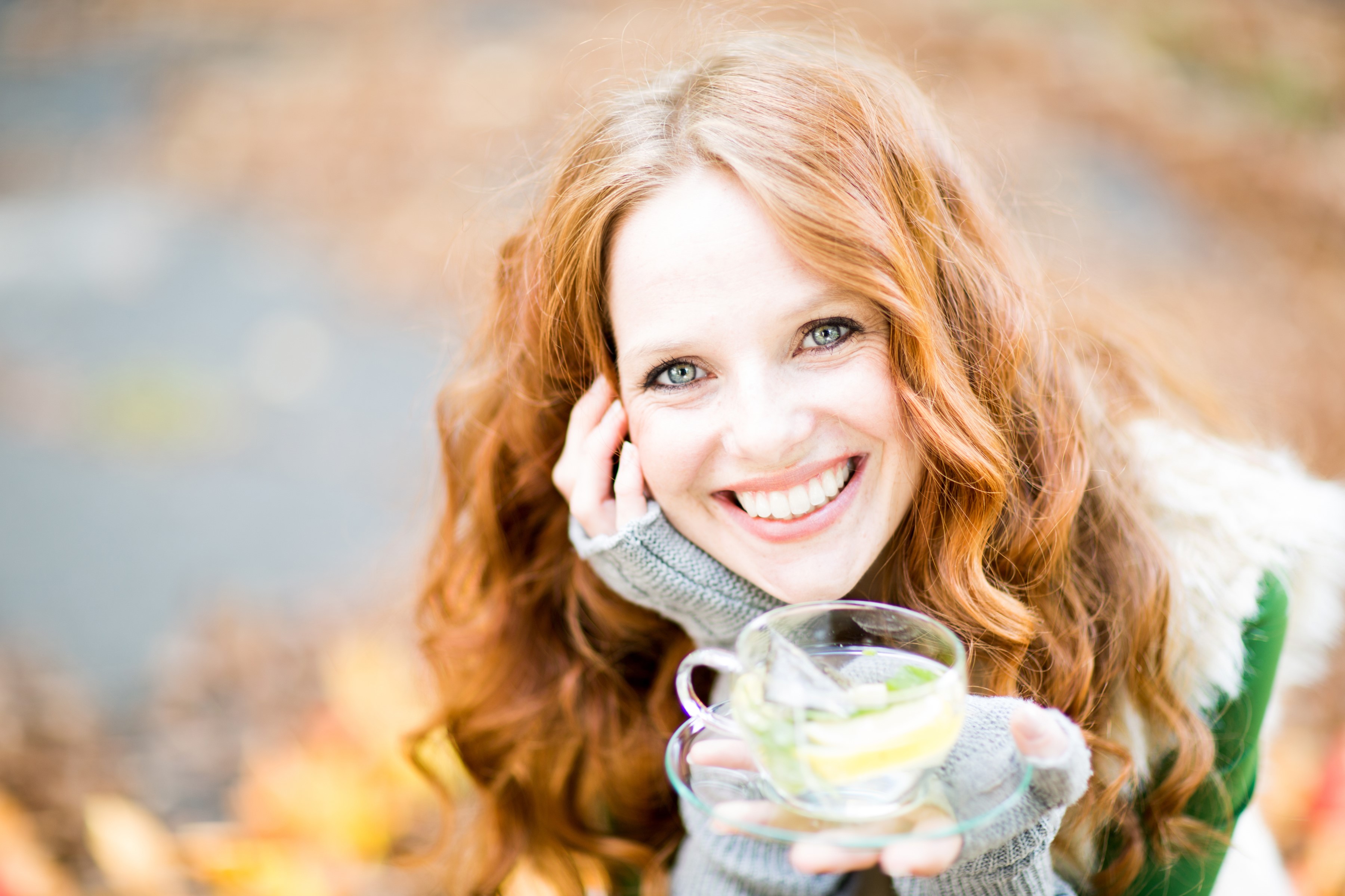 Redhead woman holding a cup of tea outdoors HD Wallpaper
