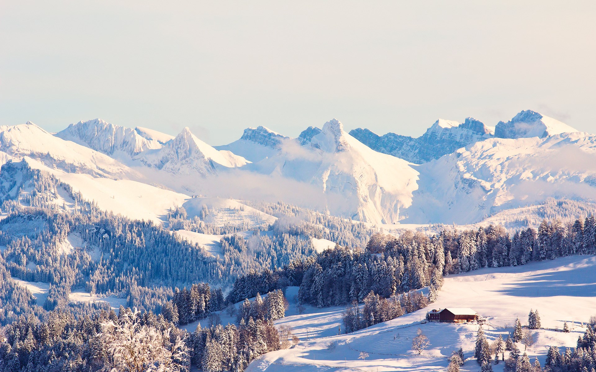 Snowy mountain range with a small cabin HD Wallpaper