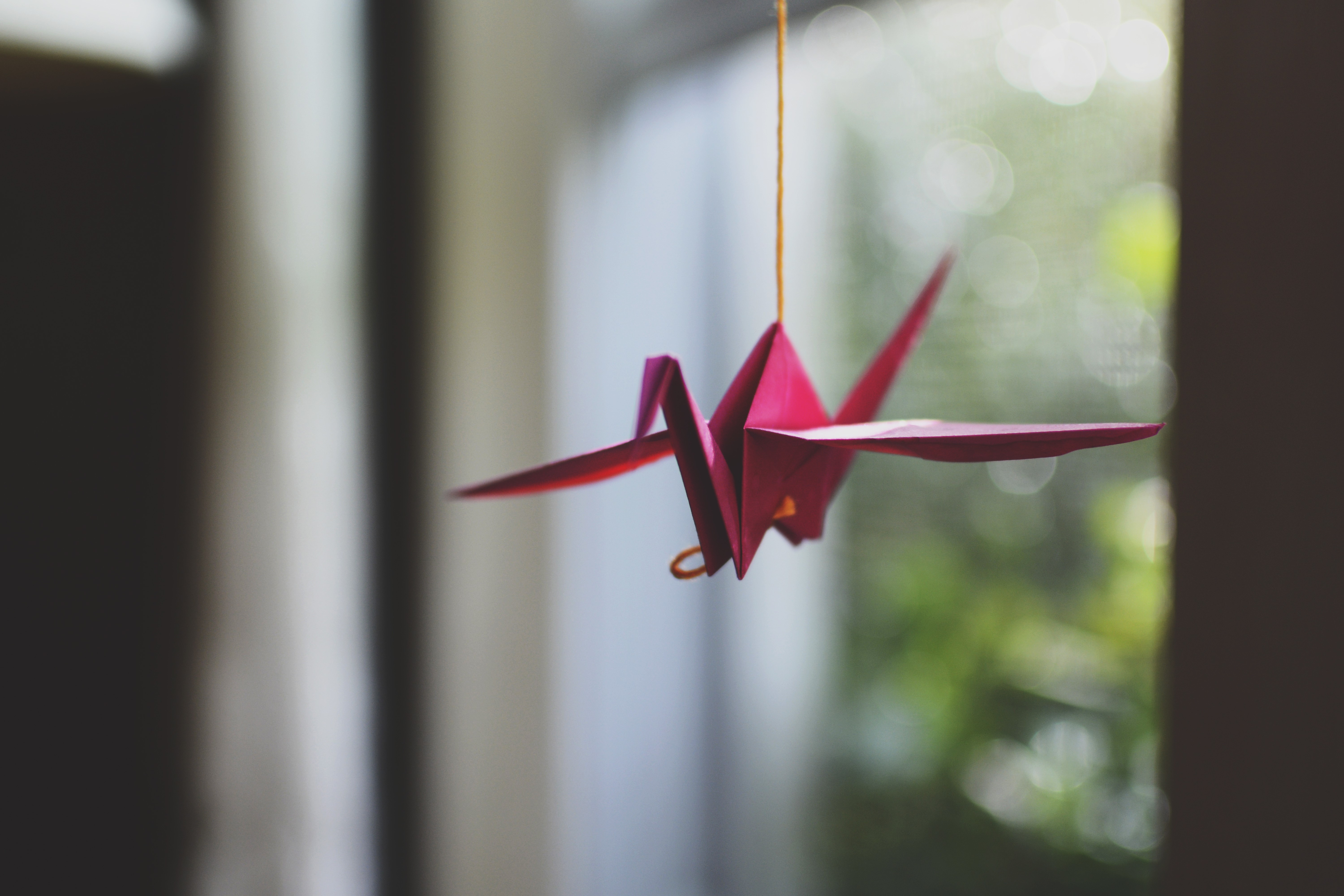 Origami crane hanging by a string HD Wallpaper